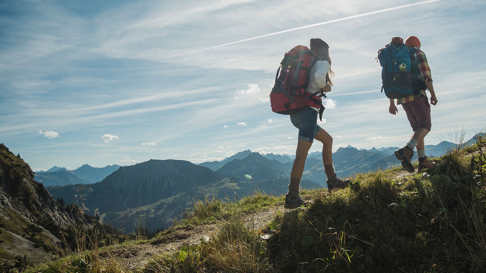 Eine Frau und ein Mann wandern in den Bergen.