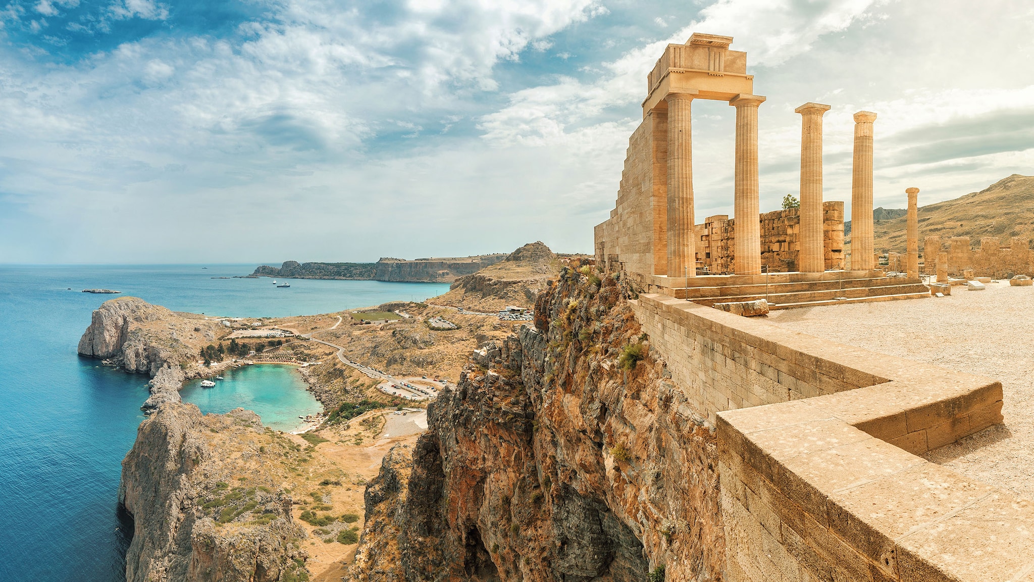 Griechische Ruinen stehen auf einer Klippe am Meer.