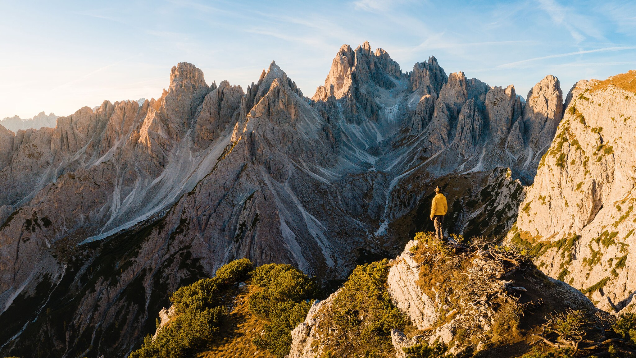 Ein Mann steht auf einem Berg, umgeben von einer Berglandschaft.