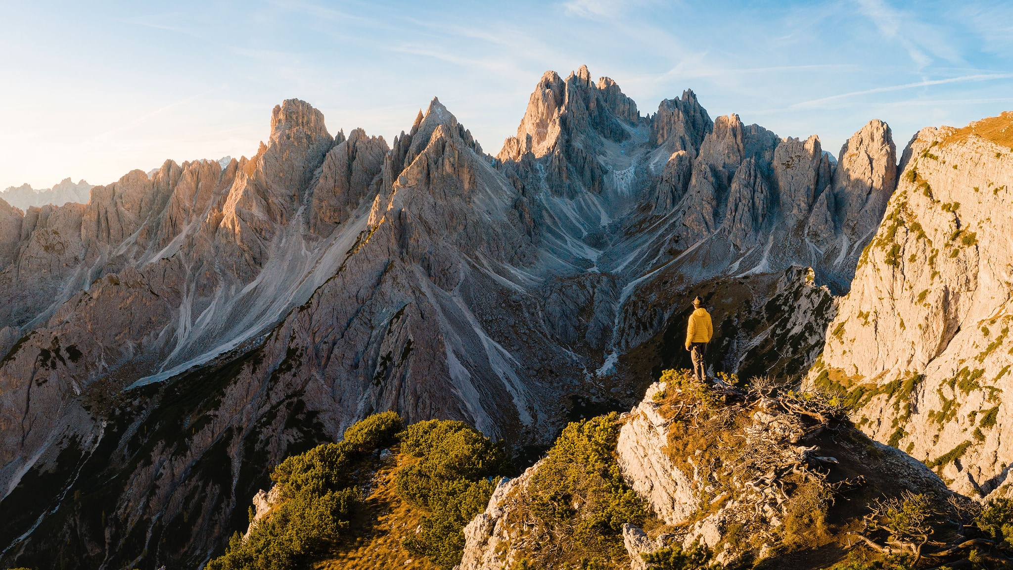 Ein Mann steht auf einem Berg, umgeben von einer Berglandschaft.