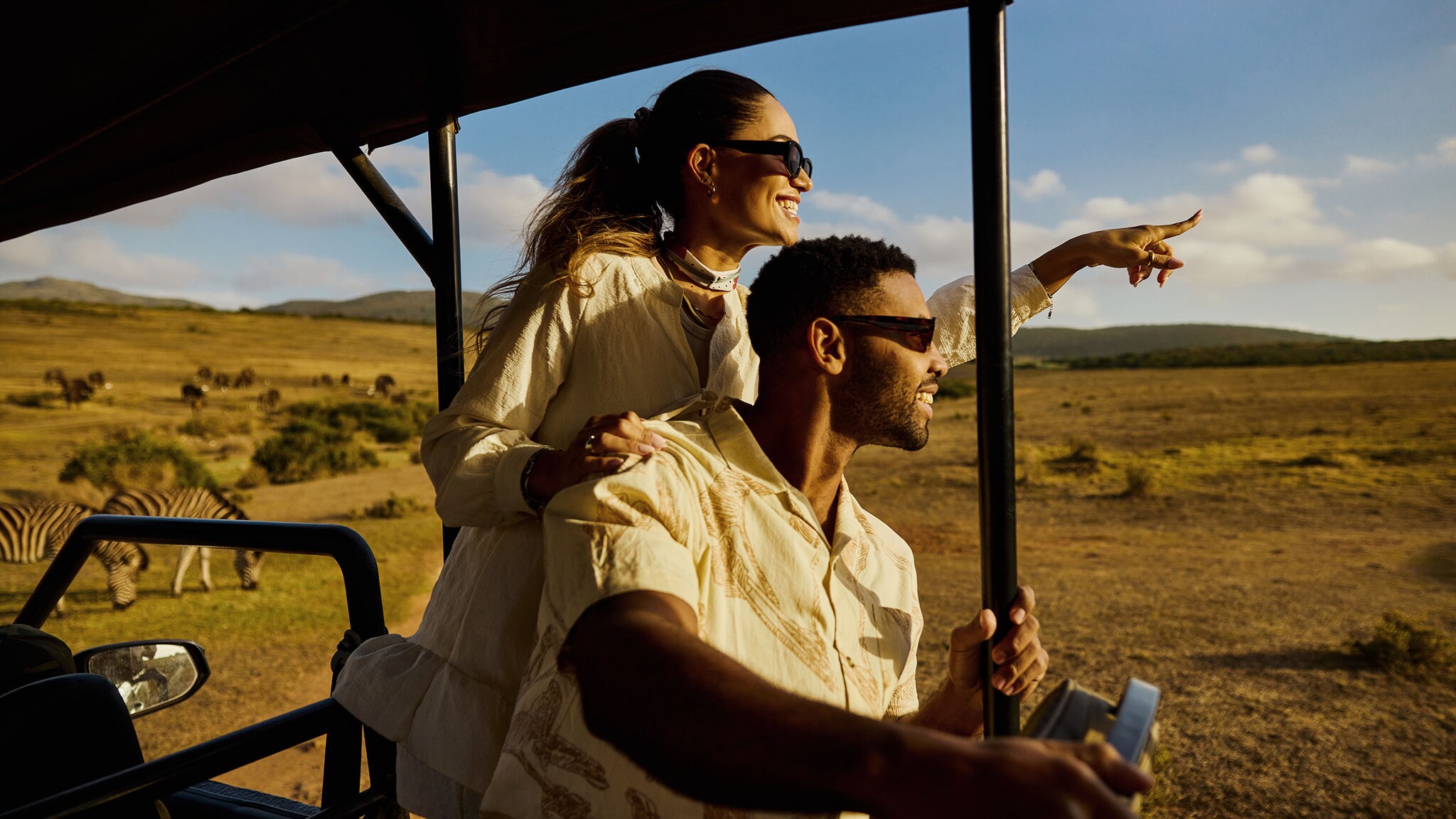 Ein Mann und eine Frau fahren in der Wüste mit einem Auto.