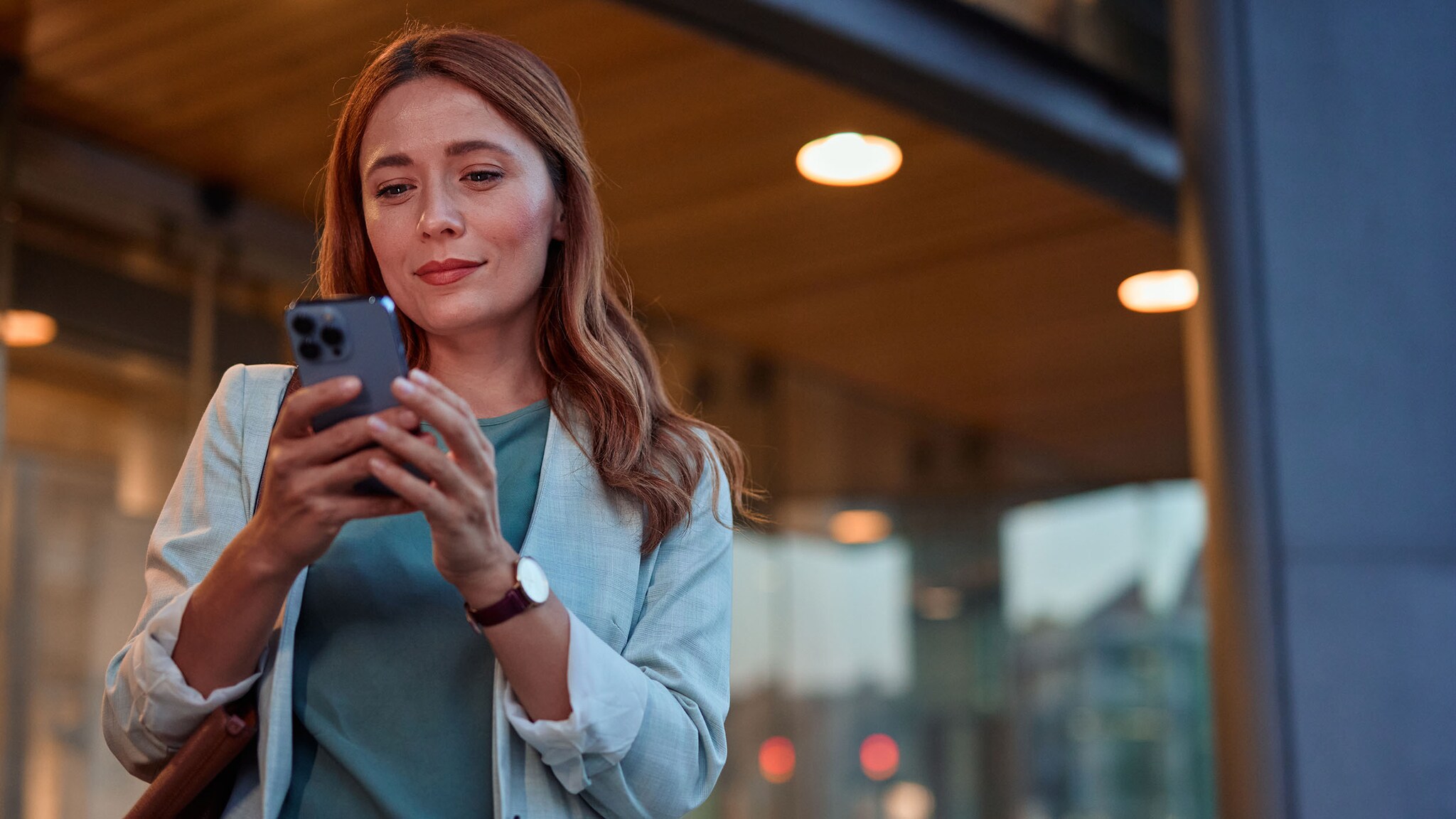 Eine Frau schaut auf ihr Smartphone.