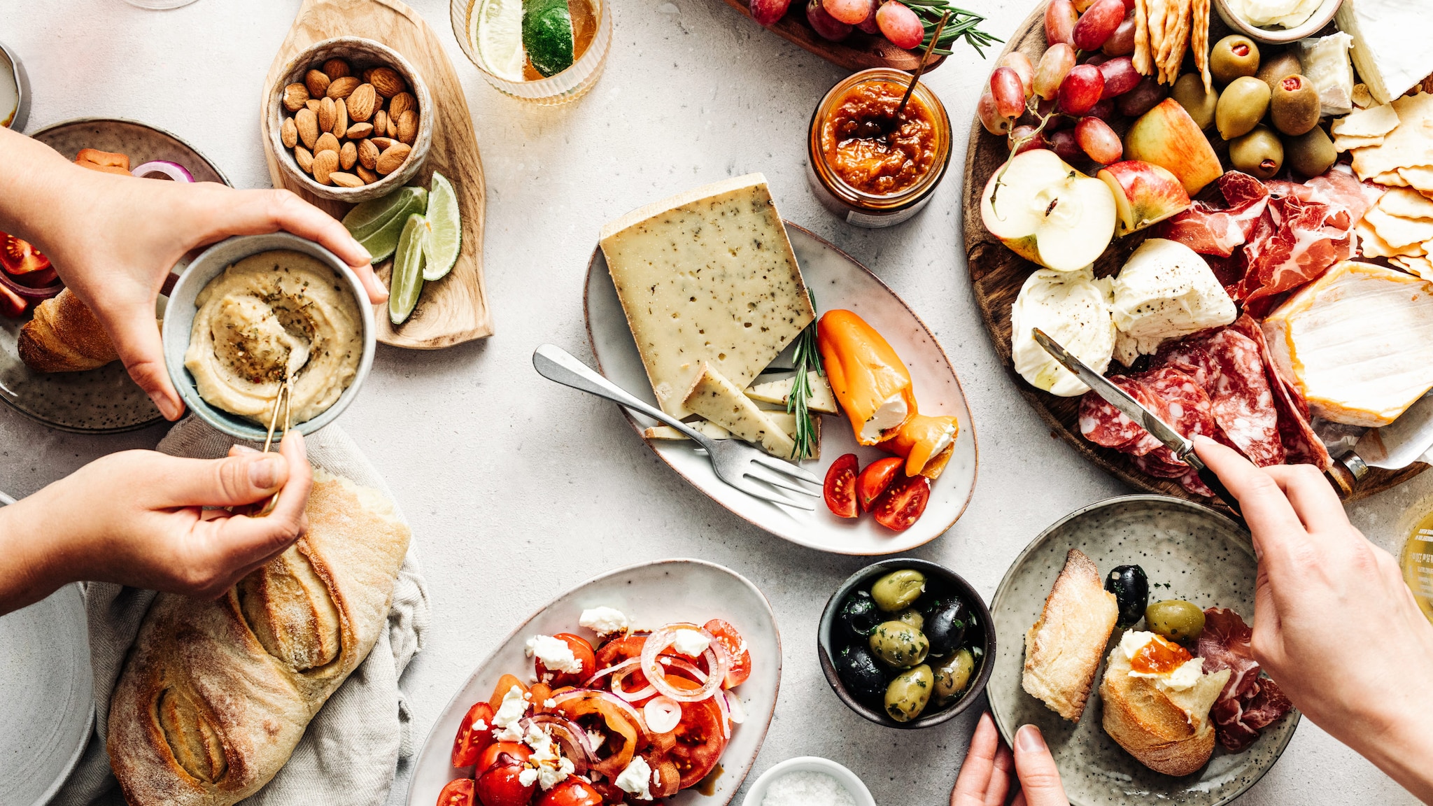 Aufsicht auf einen gedeckten Tisch mit vielen Speisen und Delikatessen.