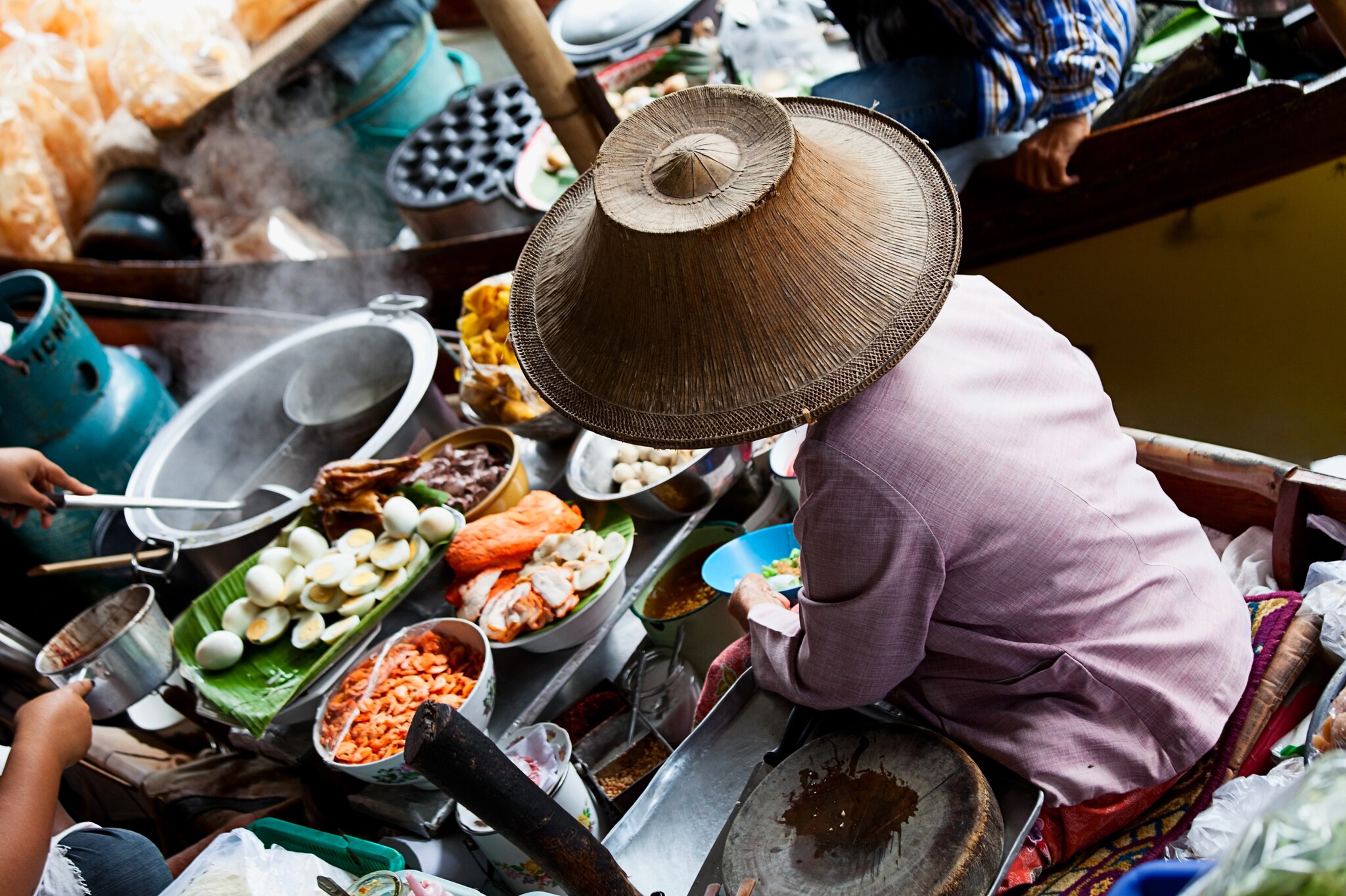 Frau verkauft Streetfood auf einem Boot in Thailand