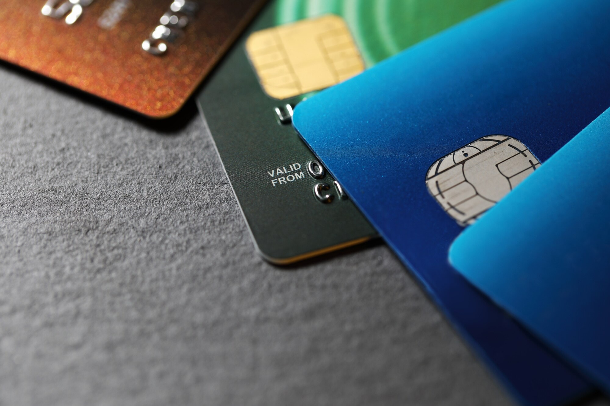 Nahaufnahme von vier unterschiedlich farbigen Kreditkarten, die versetzt übereinander liegen.