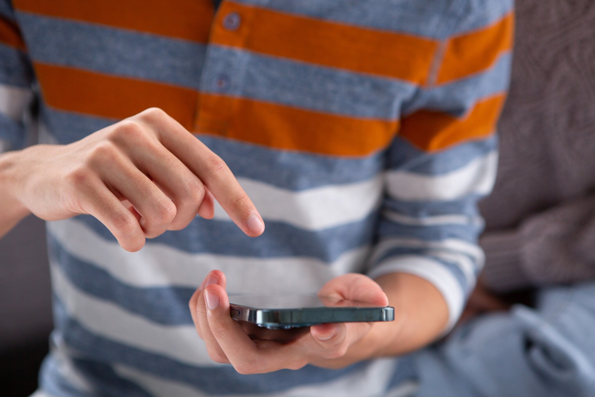 Artikelbild Person zeigt auf sein iPhone