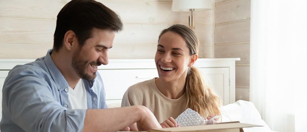 customer-journey-mapping-h glueckliches-junges-paar-packt-online-bestellung-aus