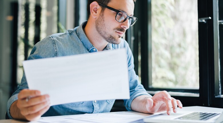 Mann untersucht am Computer die Unterlagen.