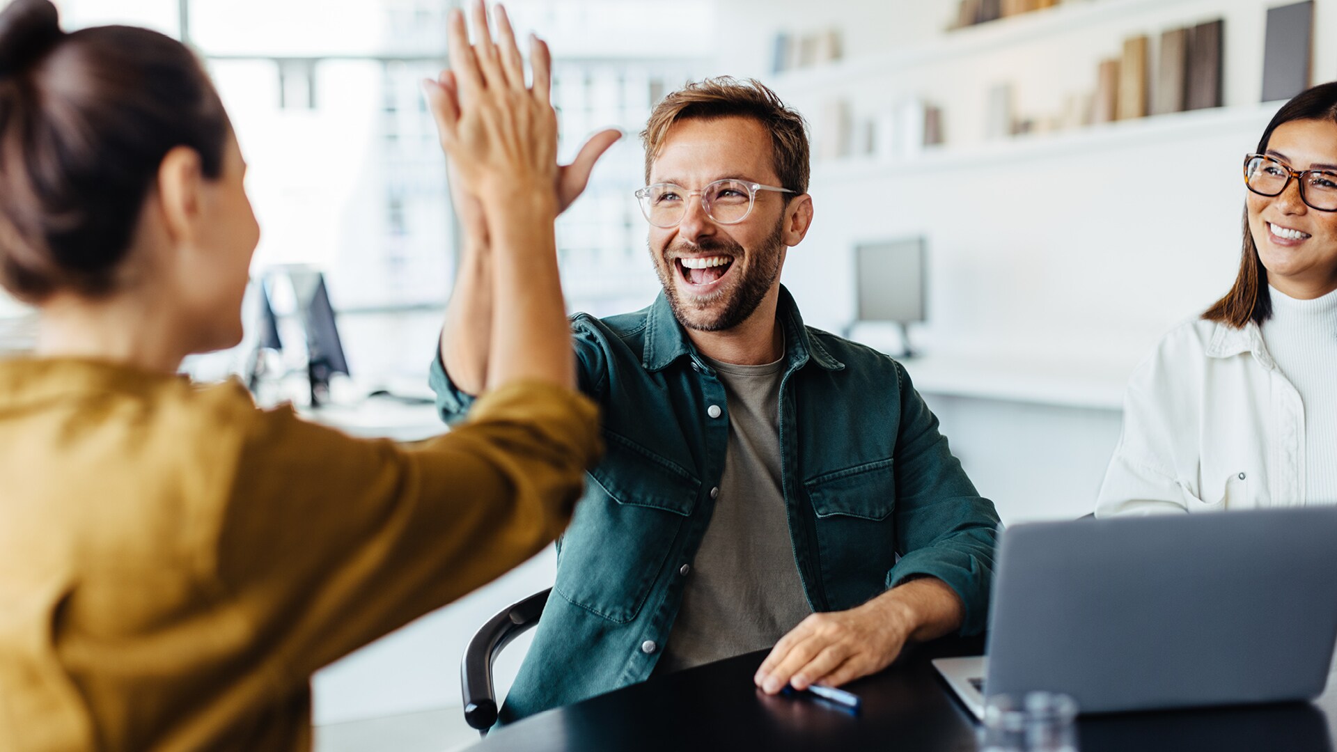 4-tage-woche-kmus-h Blogbild: Mitarbeitende geben einander ein High-Five