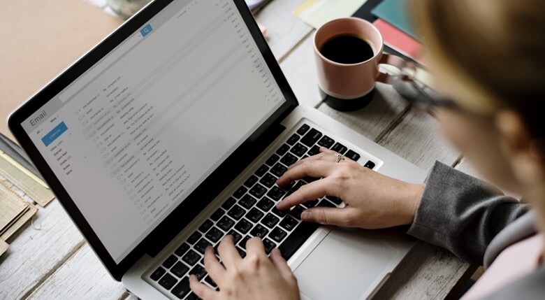 e-mail-floskeln-p Eine Person tippt auf ihrem Laptop.