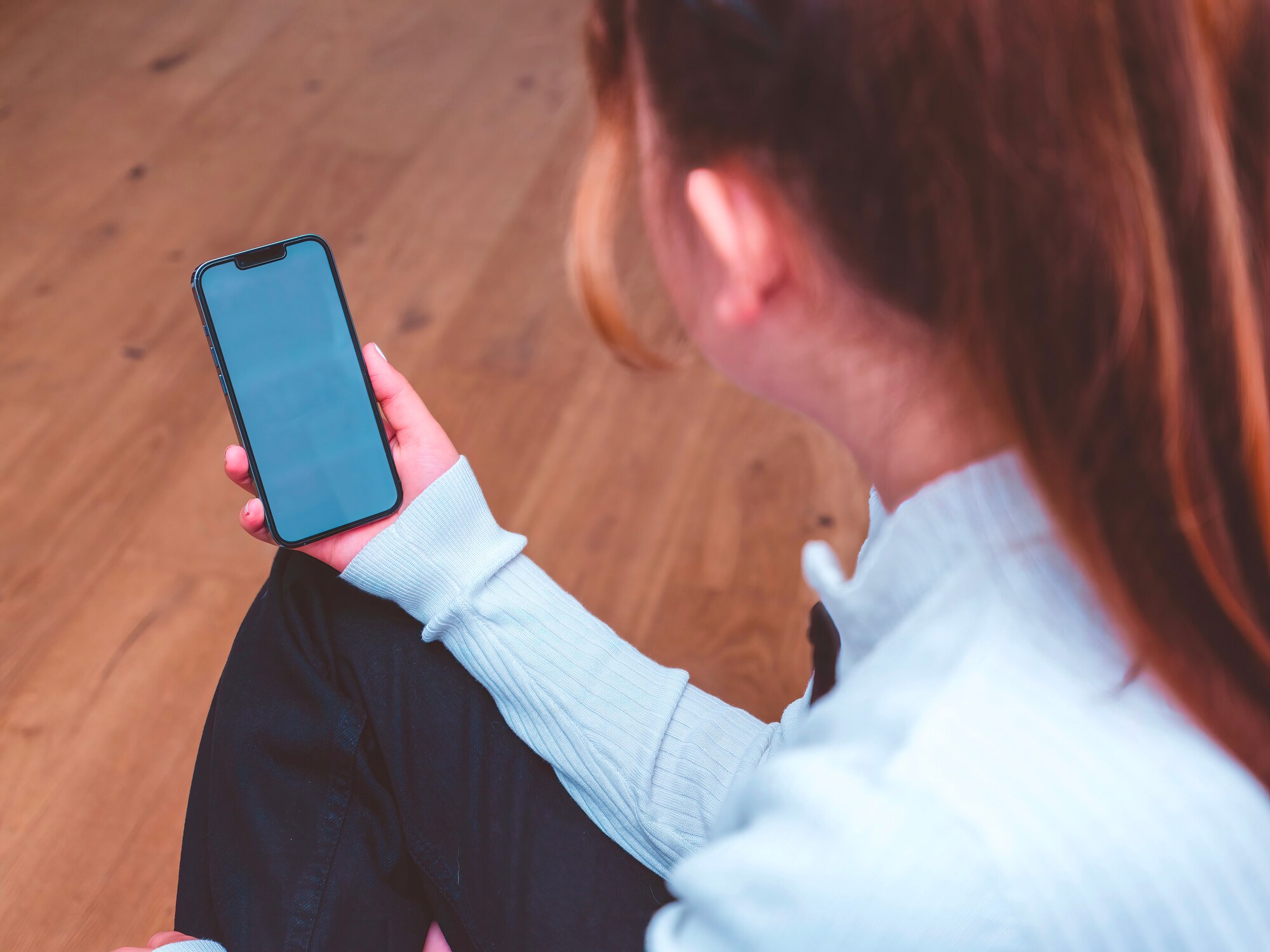 Artikelbild Person schaut auf iPhone 13