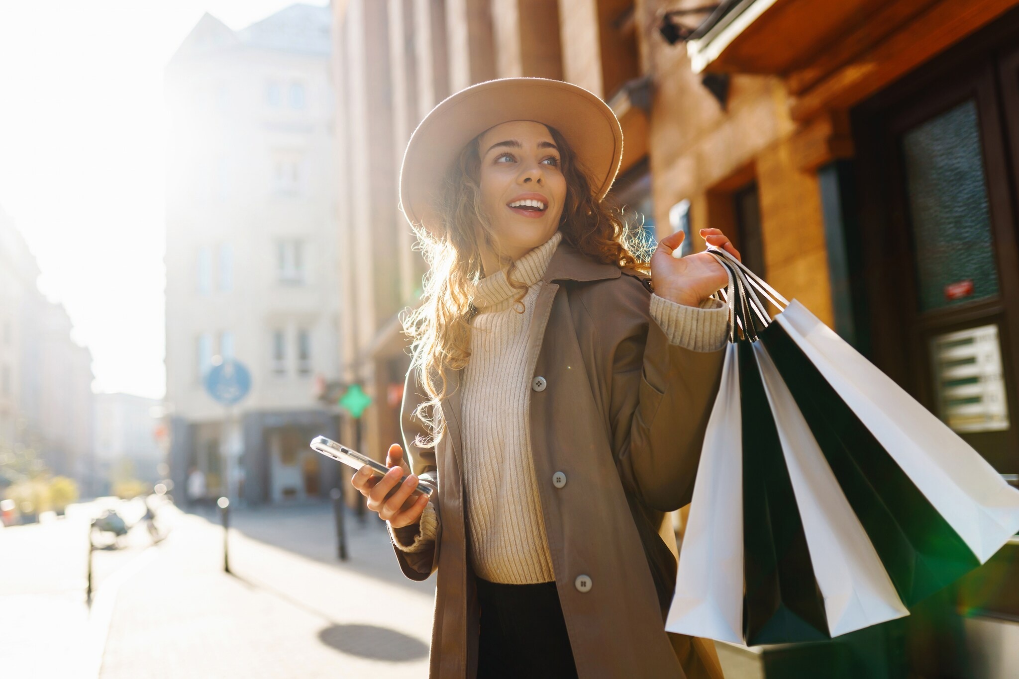 GettyImages-2162579891 Frau hält lächelnd mehrere Shopping Tüten in der Hand