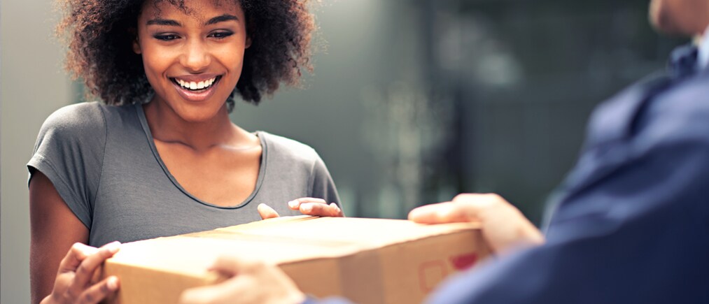 e-commerce-trends-2025 Frau enthält lächelnd ein Paket