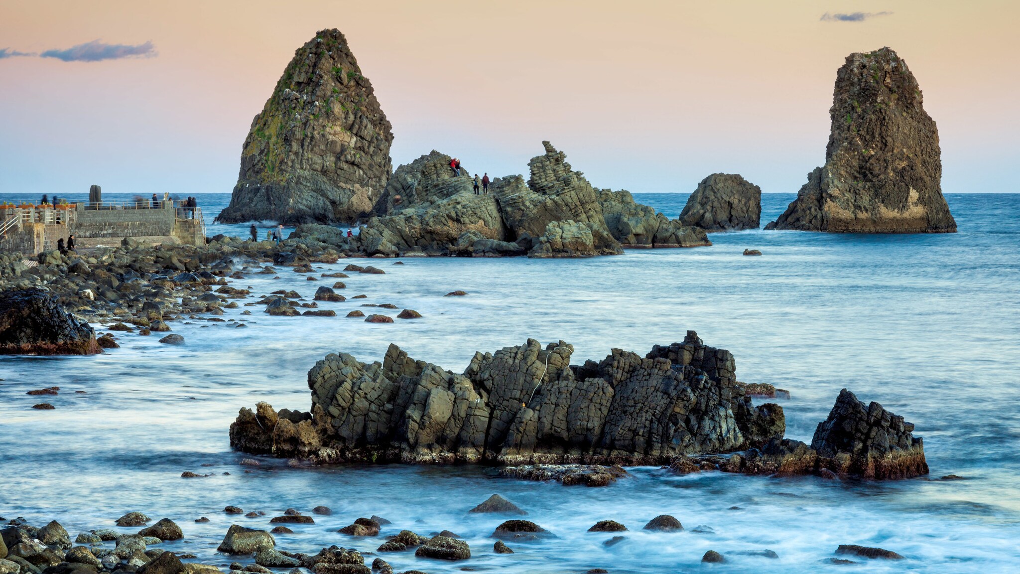 Im Meer ragen verschiedene Felsen aus dem Wasser empor.