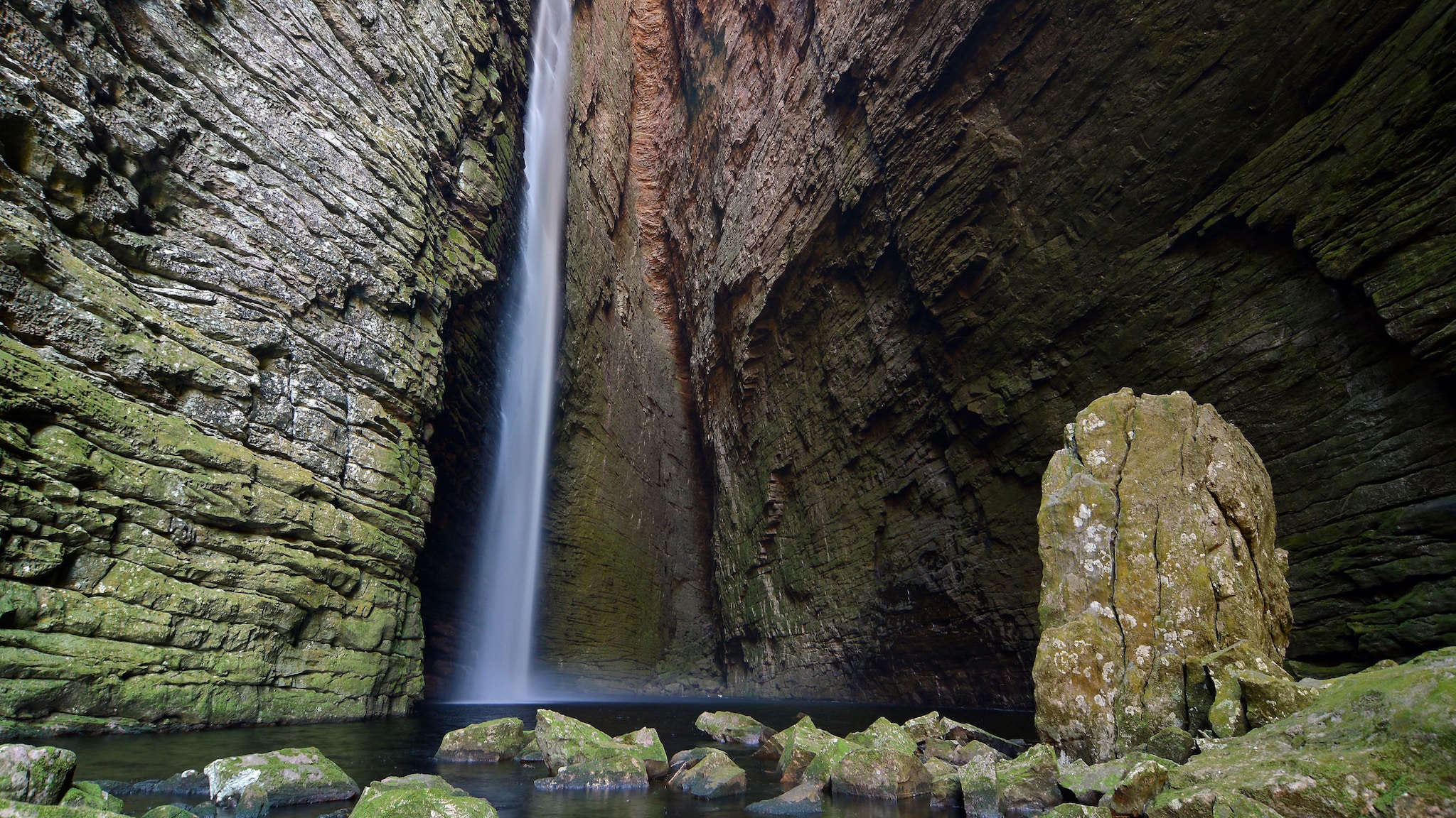 amex-magazin-wasserfaelle-brasilien-klippen-see In den Klippen von Bergen fließt ein Wasserfall und landet in einen kleinen See.