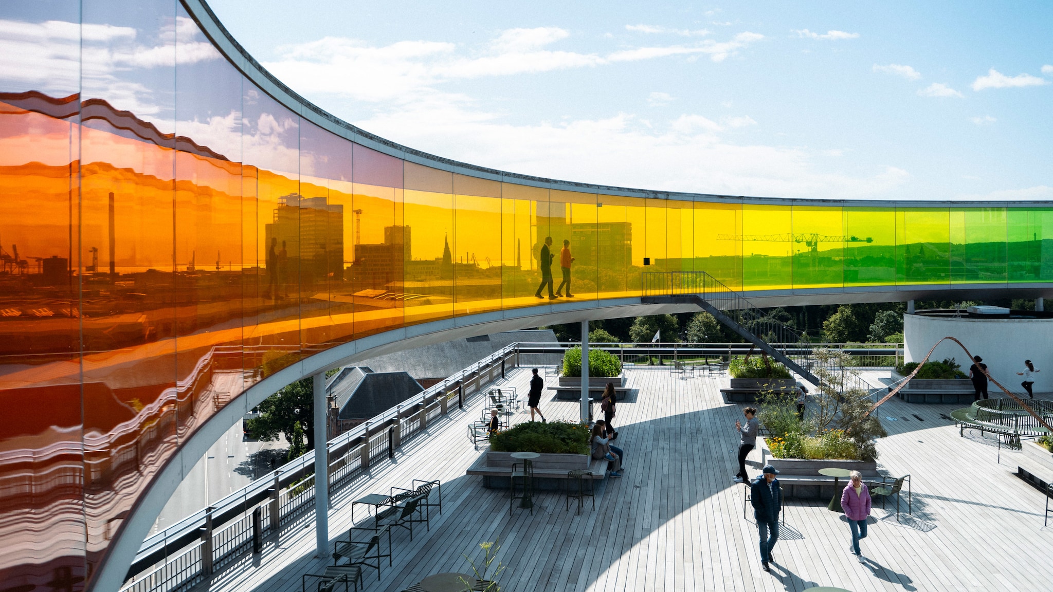 amex-magazin-aarhus-daenemark-gehweg-glas ber einer Dachterrasse steht ein riesiger, bunter Gehweg aus Glas.