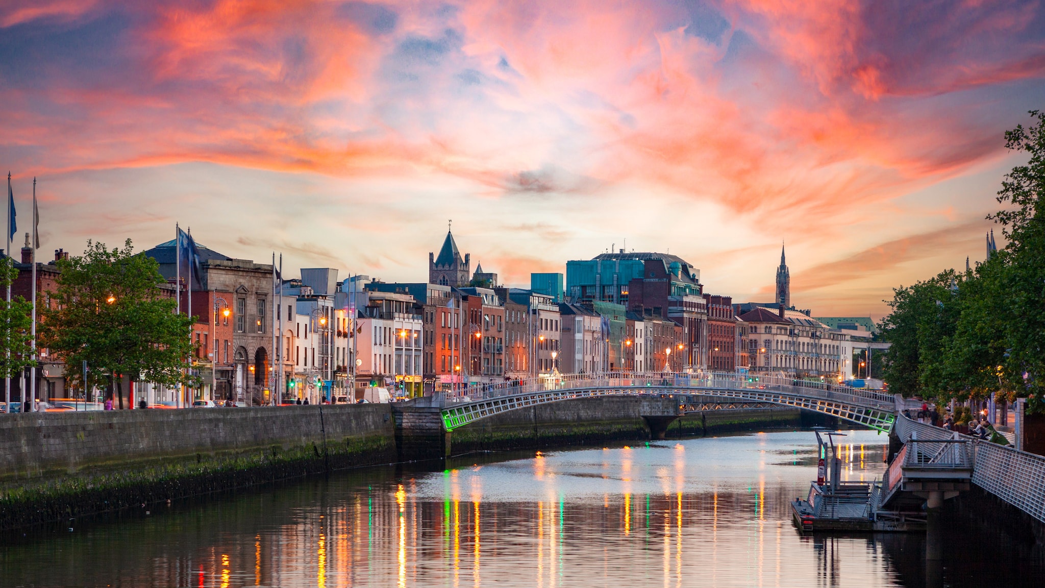 amex-magazin-dublin-geheimtipps-bruecke-fluss Eine Brücke führt über einen breiten Fluss, der durch eine Stadt fließt.