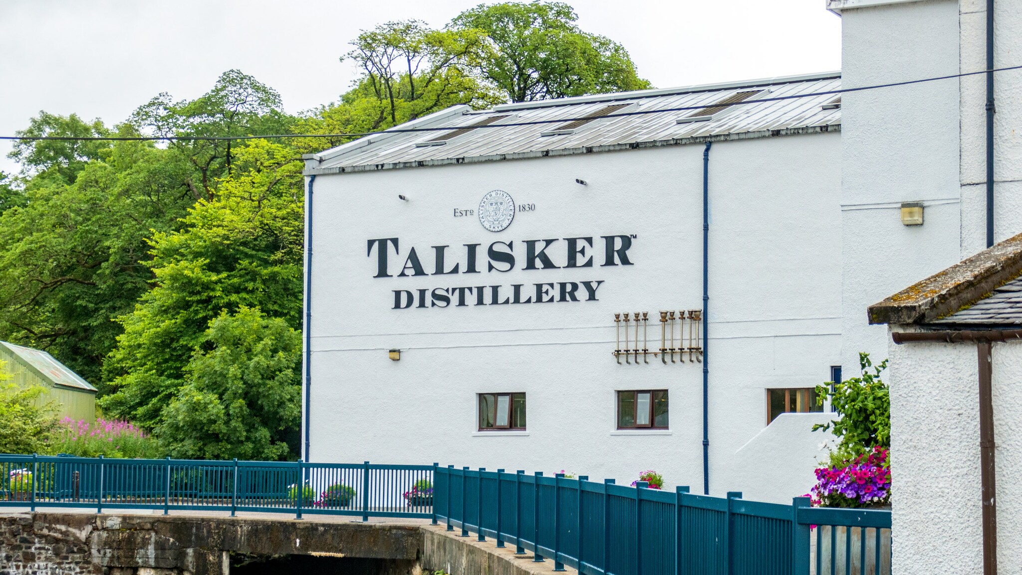 Ein weißes Gebäude steht an einer Brücke.