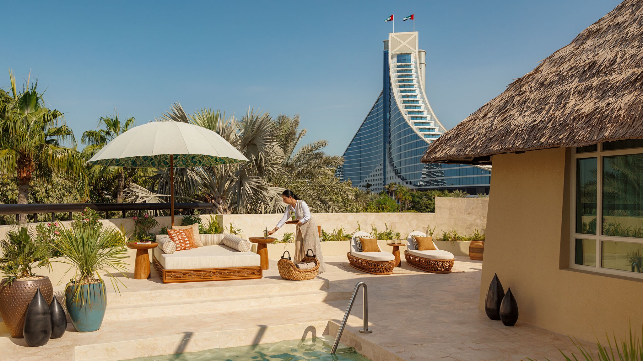 Auf der Terrasse eines Pools stehen Liegestühle.