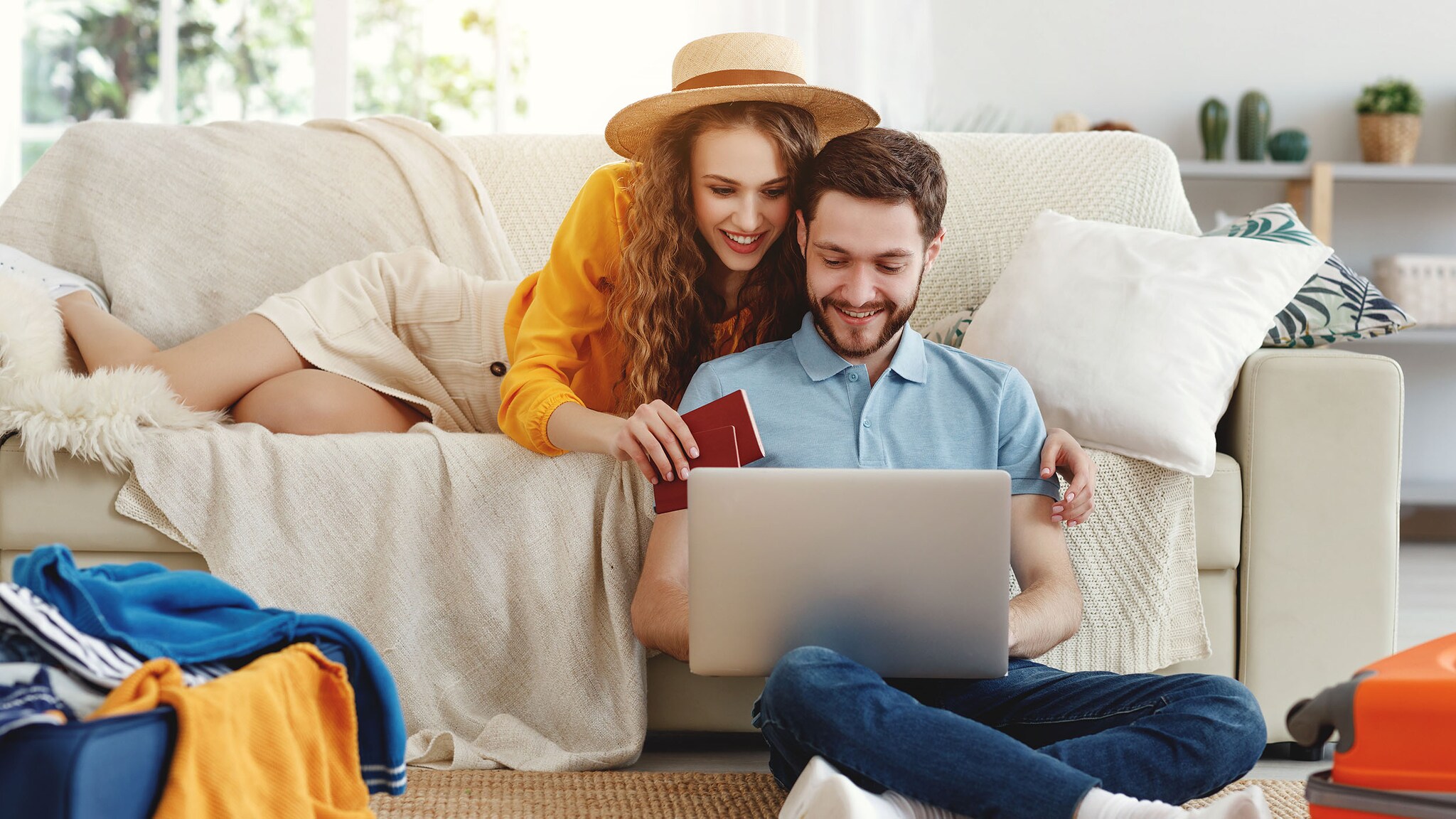 Eine Frau und ein Mann sitzen auf einem Sofa und schauen in einen Laptop.