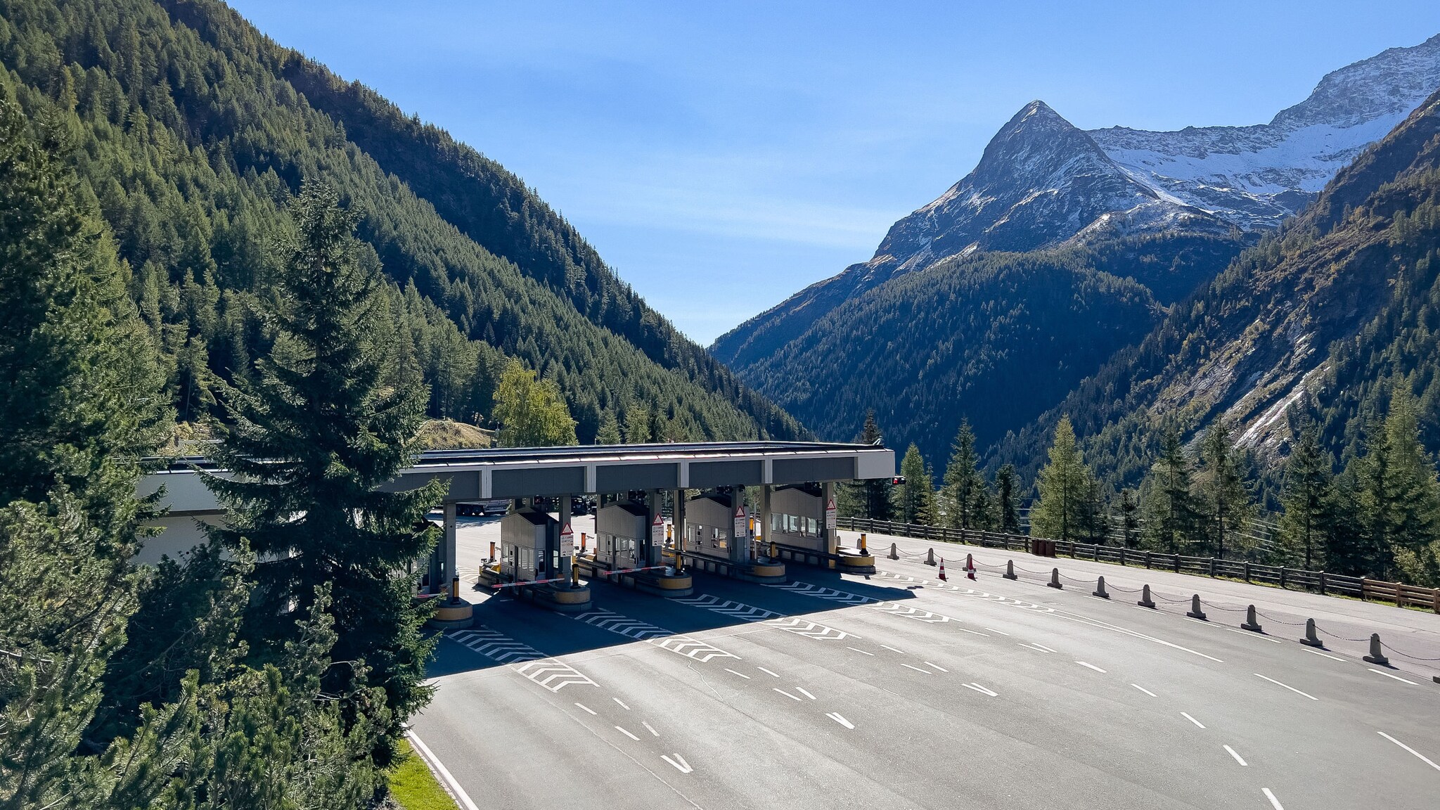 Mehrspurige Mautstation auf einer leeren Straße in den Bergen.