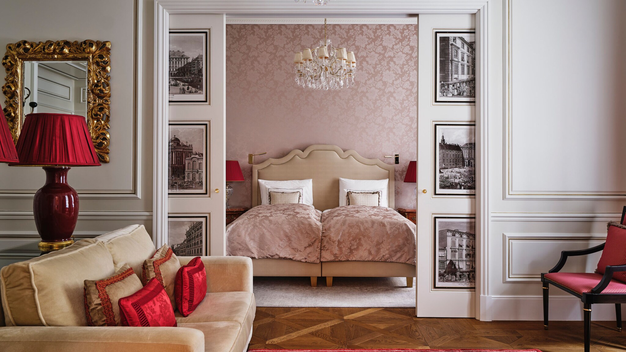 Blick ins Schlafzimmer mit Doppelbett unter einem Kronleuchter in einer luxuriösen, prunkvollen Hotelsuite.