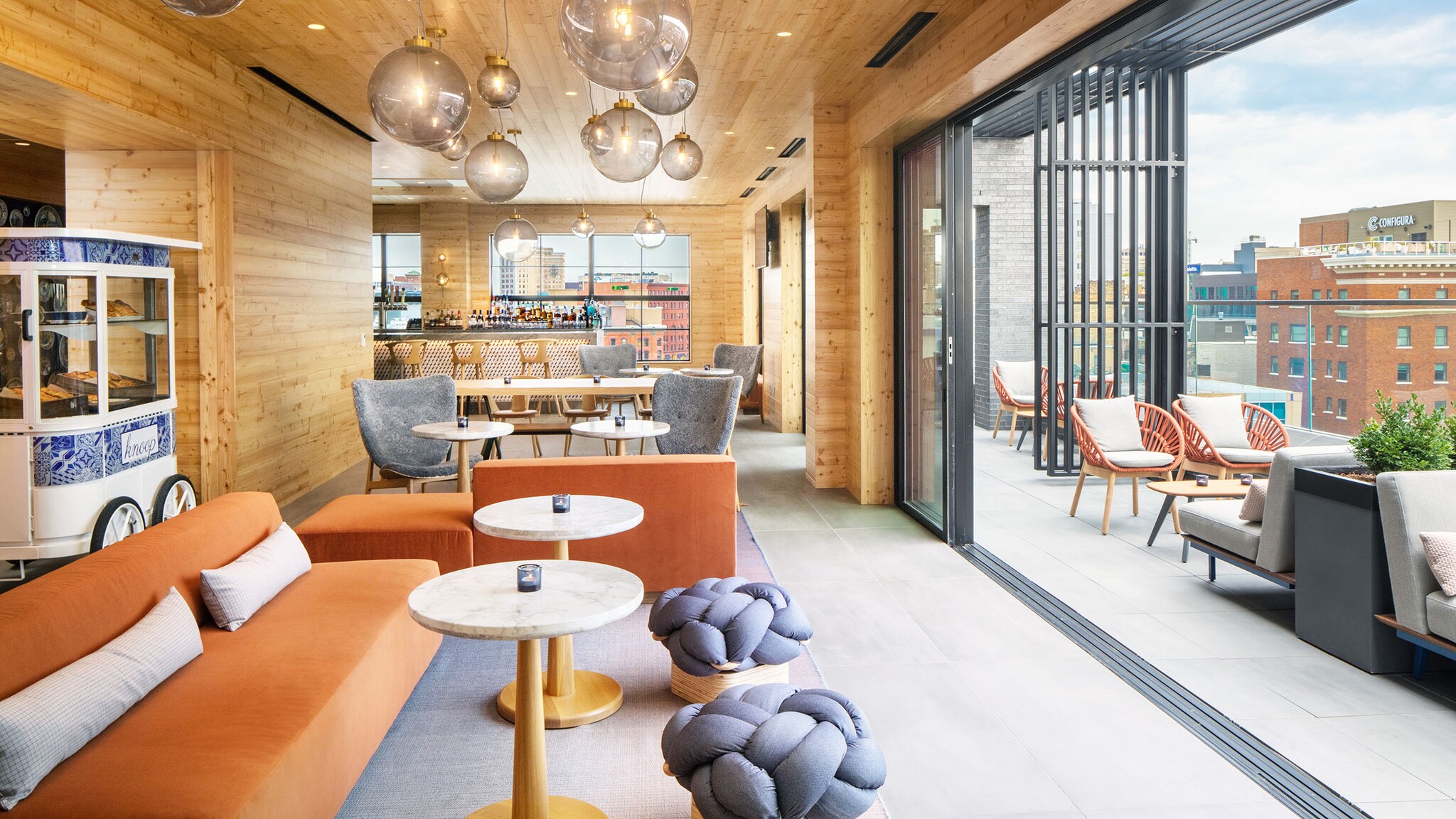 Ein Restaurant mit Holzwänden hat eine große Fensterfront mit einer Terrasse.