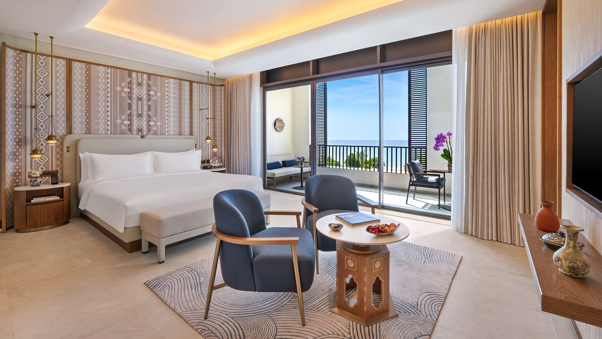 Helles, modernes Hotelzimmer mit Doppelbett, orientalischen Designelementen und großem Balkon mit Meerblick.