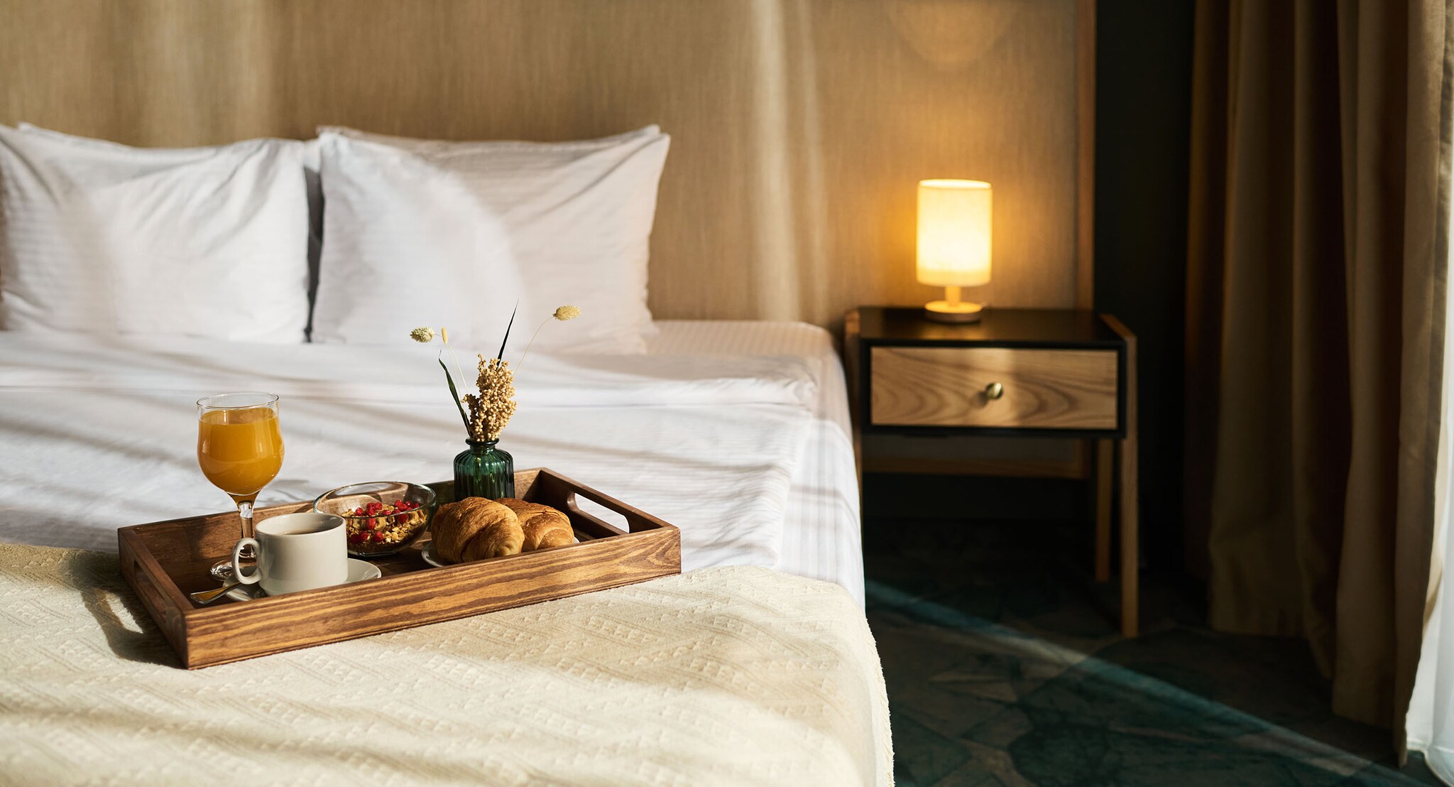 Doppelbett im Anschnitt mit einem angerichteten Frühstückstablett.