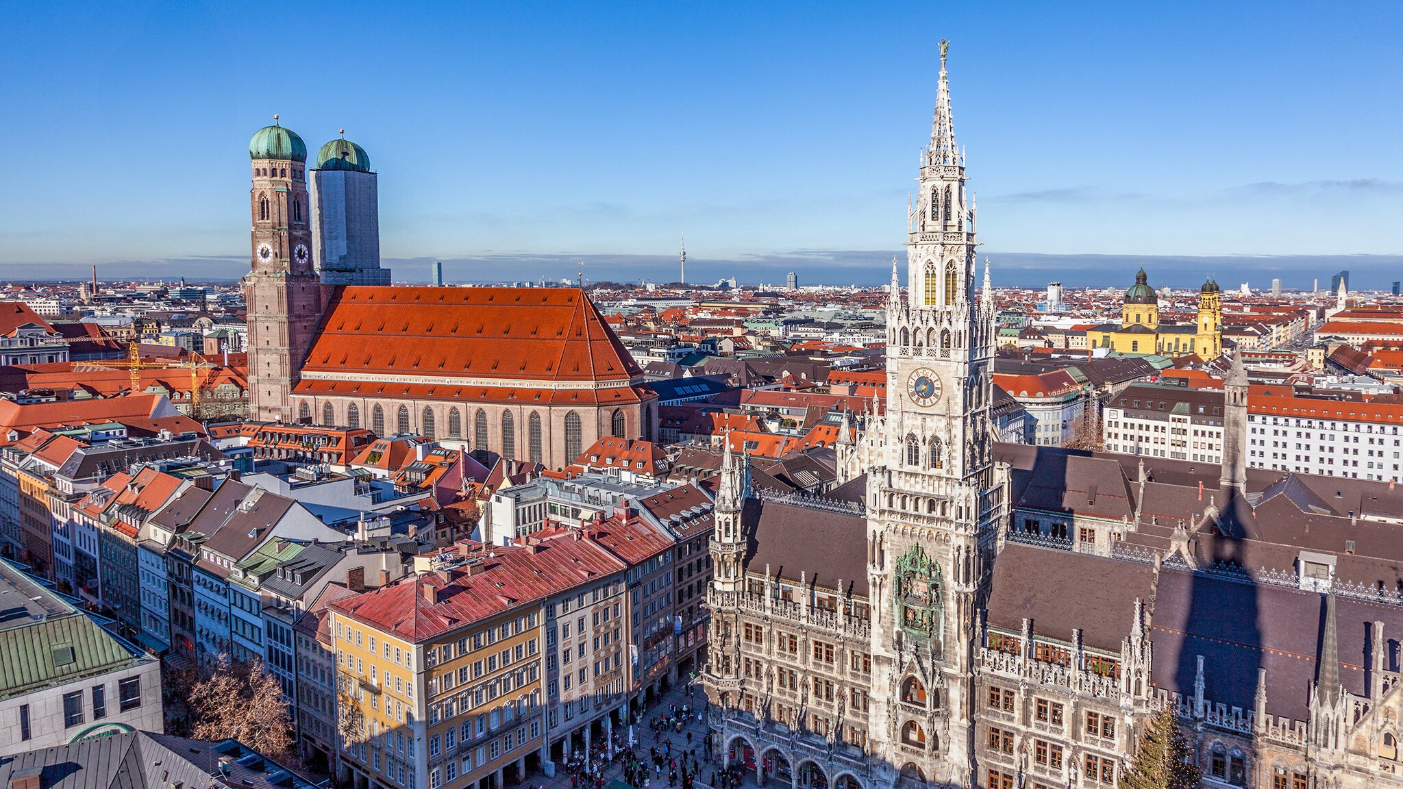 Luftaufnahme Altstadtpanorama von München mit Dom und Rathaus bei Sonnenschein.