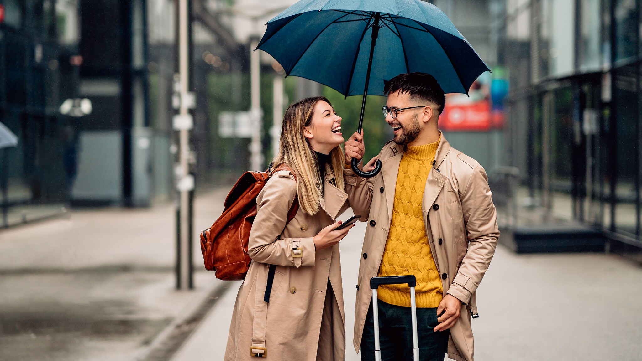 Ein Mann und eine Frau stehen unter einem Regenschirm.