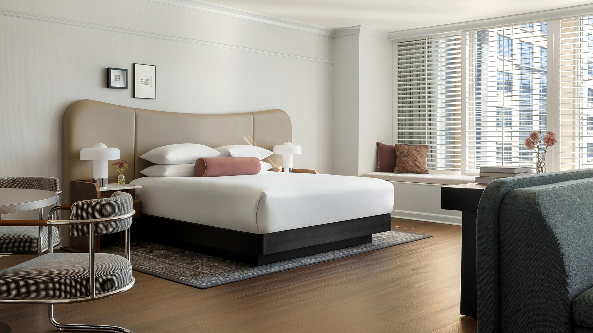 Helle, modern eingerichtete Hotelsuite mit Doppelbett in urbanem Setting.