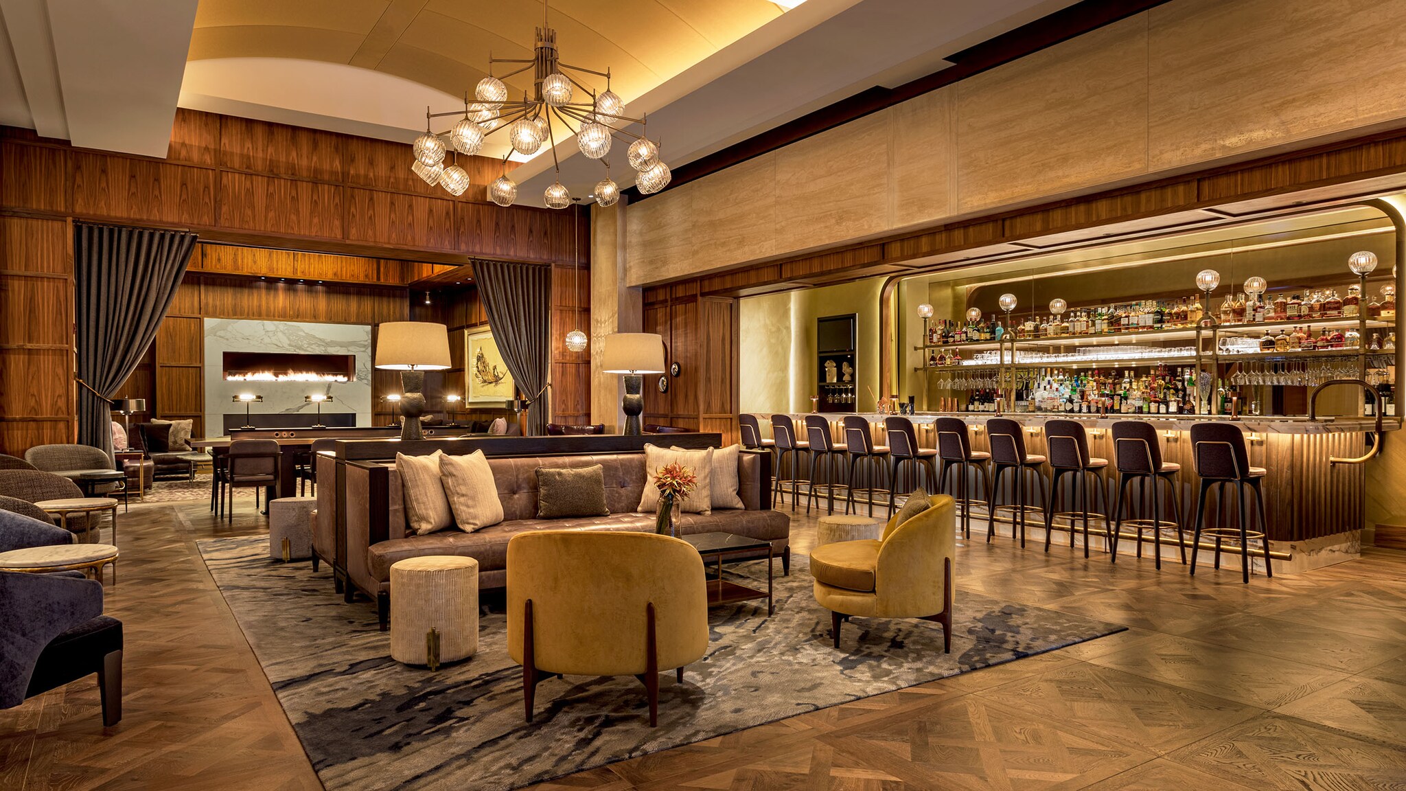 Vor einer Hotelbar stehen Sessel und Tische.