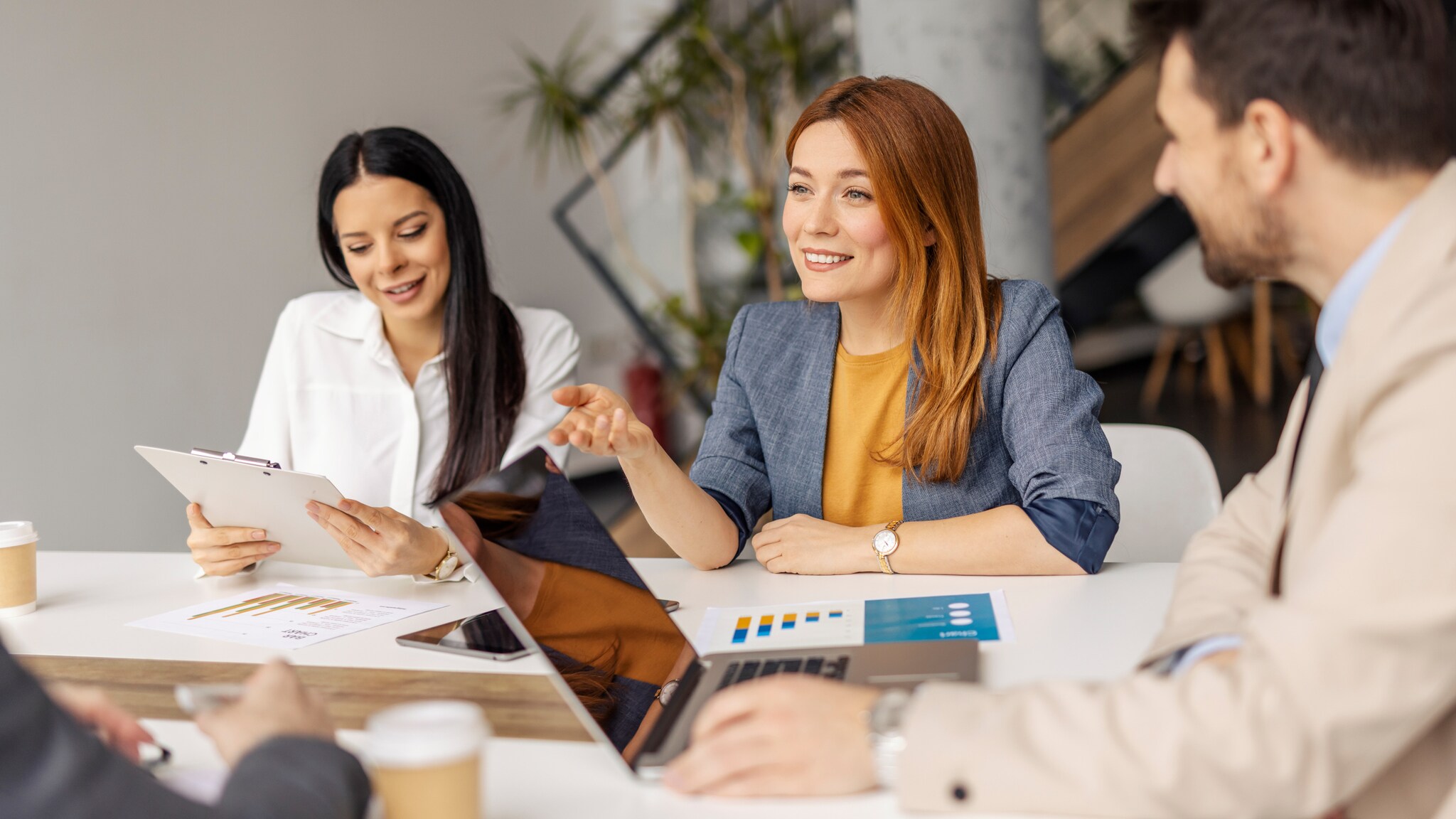amex-sbs-amex-business-karten-kmu-zwei-frauen-mann Zwei Frauen und ein Mann sitzen an einem Konferenztisch.