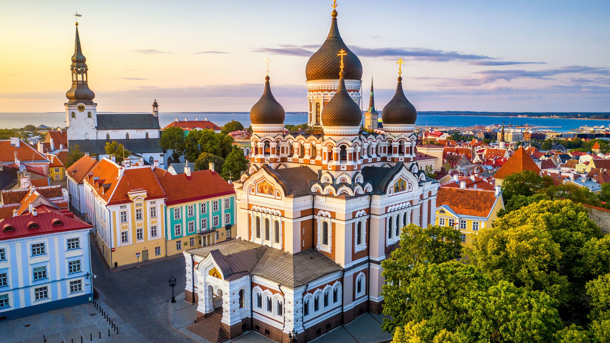 Prächtige orthodoxe Kirche mit Zwiebeltürmen auf einer Anhöhe in einer Altstadt, im Hintergrund Meerespanorama.