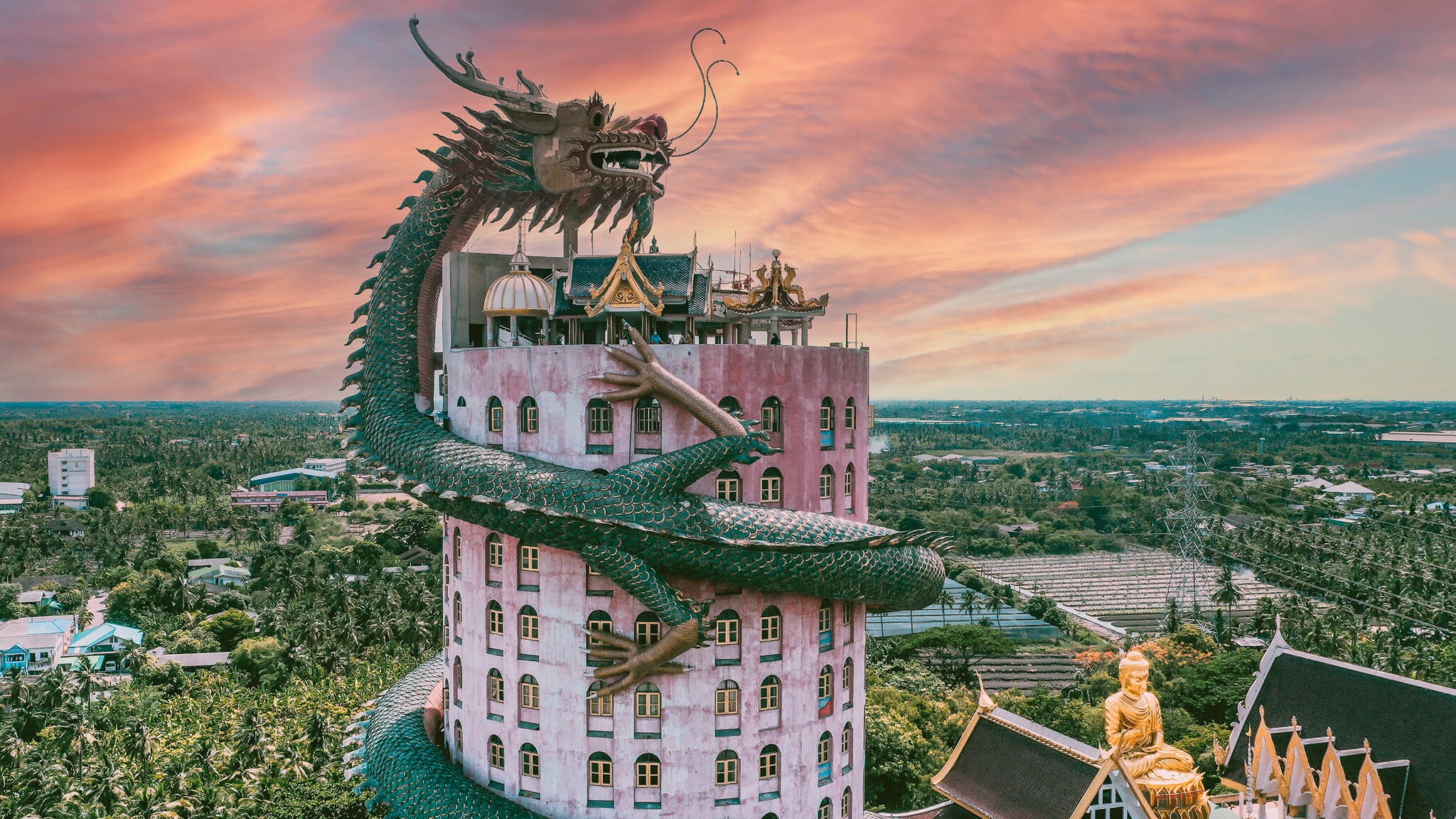 An einem Turm schlängelt sich eine Skulptur in Form eines Drachen.
