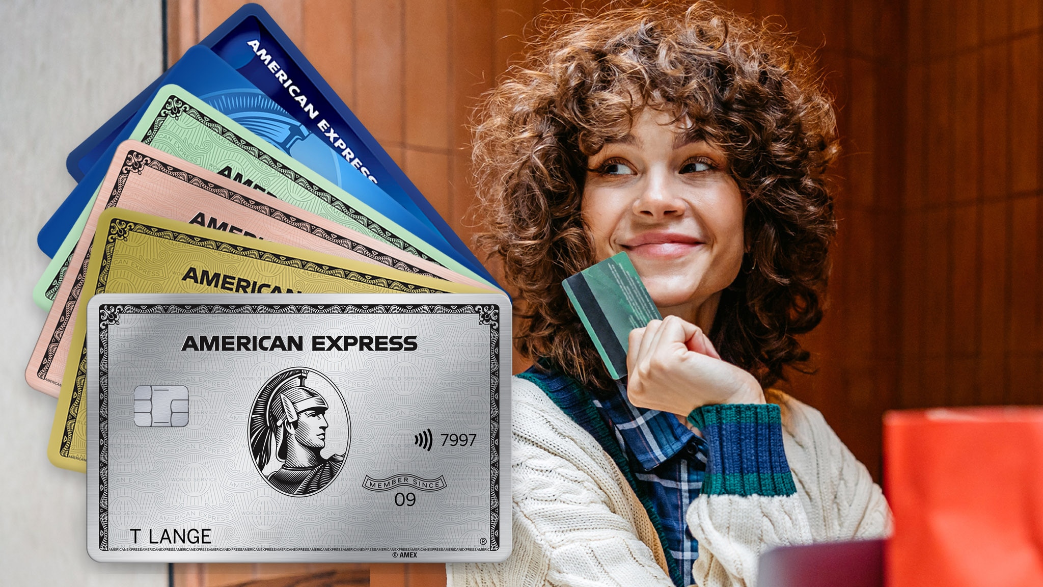 Kreditkartenfarben Eine junge Frau mit Locken sitzt an einem Laptop und hält lächelnd eine grüne Kreditkarte hoch, davor eine Collage von mehreren aufgefächerten Kreditkarten von American Express in unterschiedlichen Farben.