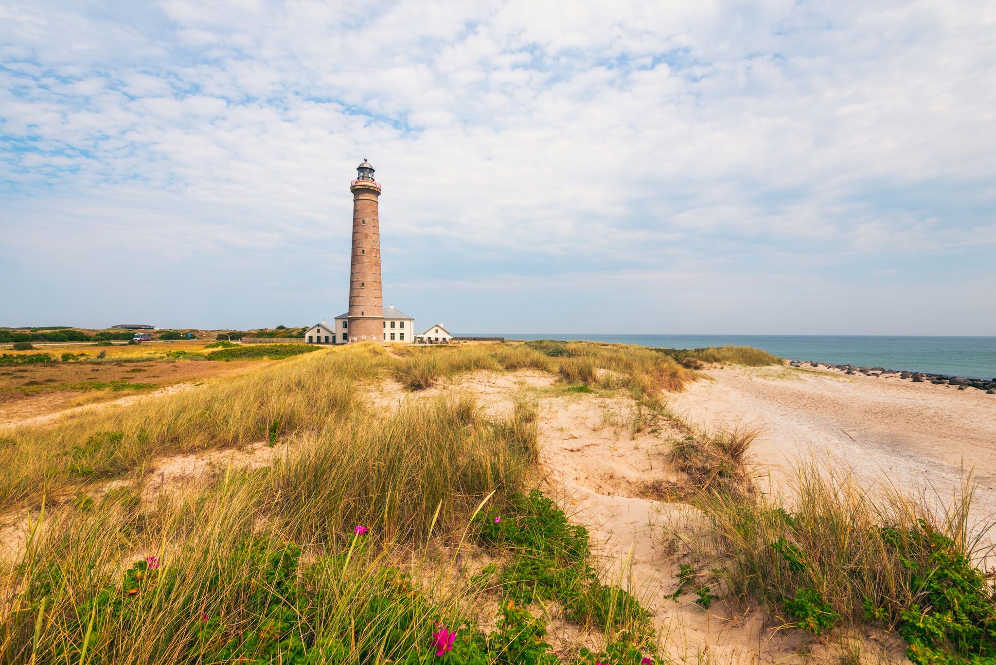 Leuchtturm in den Dünen am Meer.