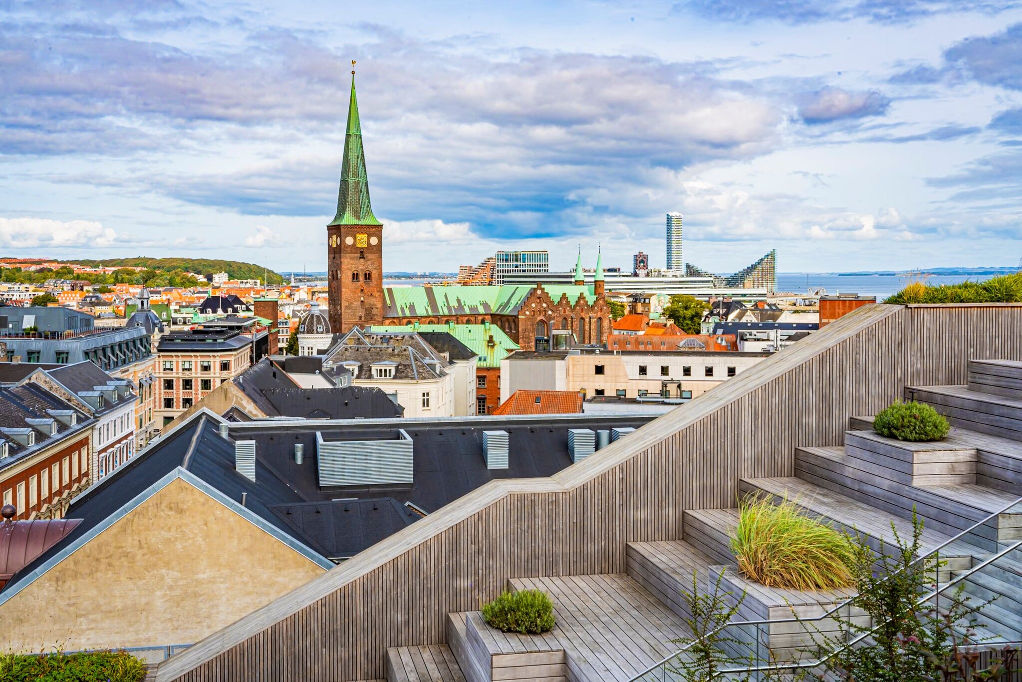 Blick von einer Terrasse auf den Kirchturm und die Dächer von Aarhus. 