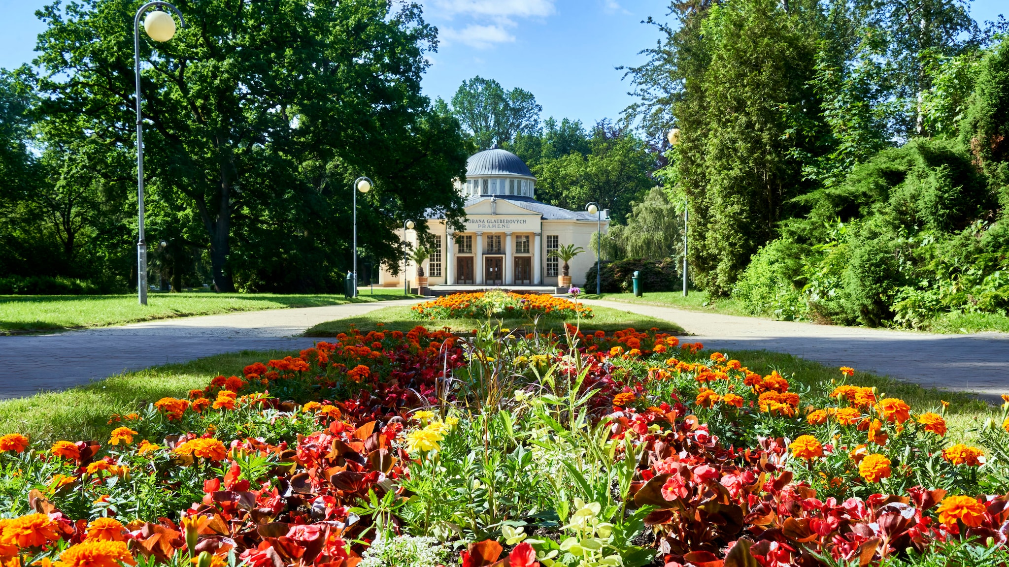 Buntes Blumenbeet vor der gelben Trinkhalle der Glaubersalzquelle in Franzensbad.