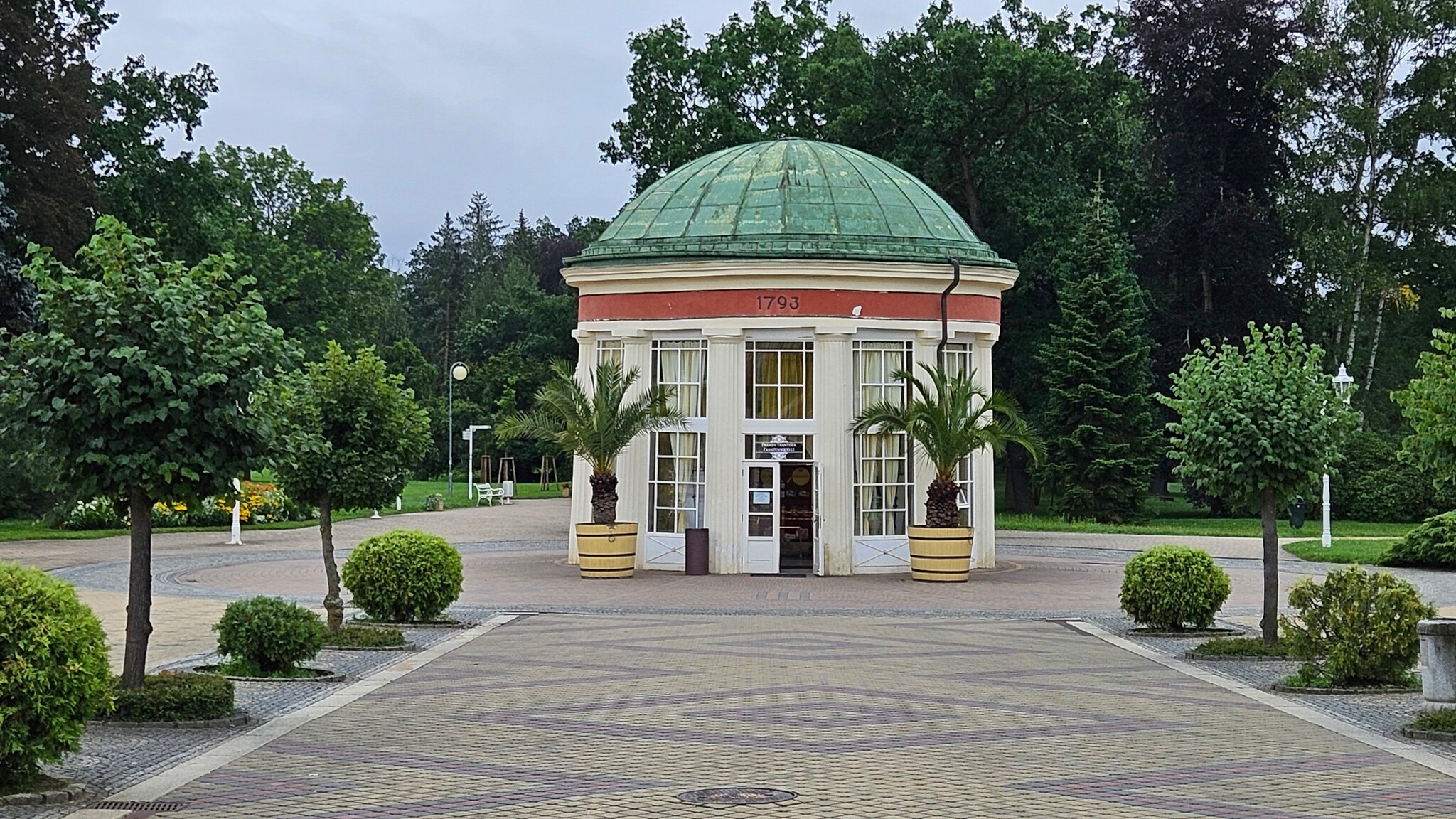 Von Bäumen gesäumter Weg führt zum runden Pavillon der bekannten Franzenquelle.
