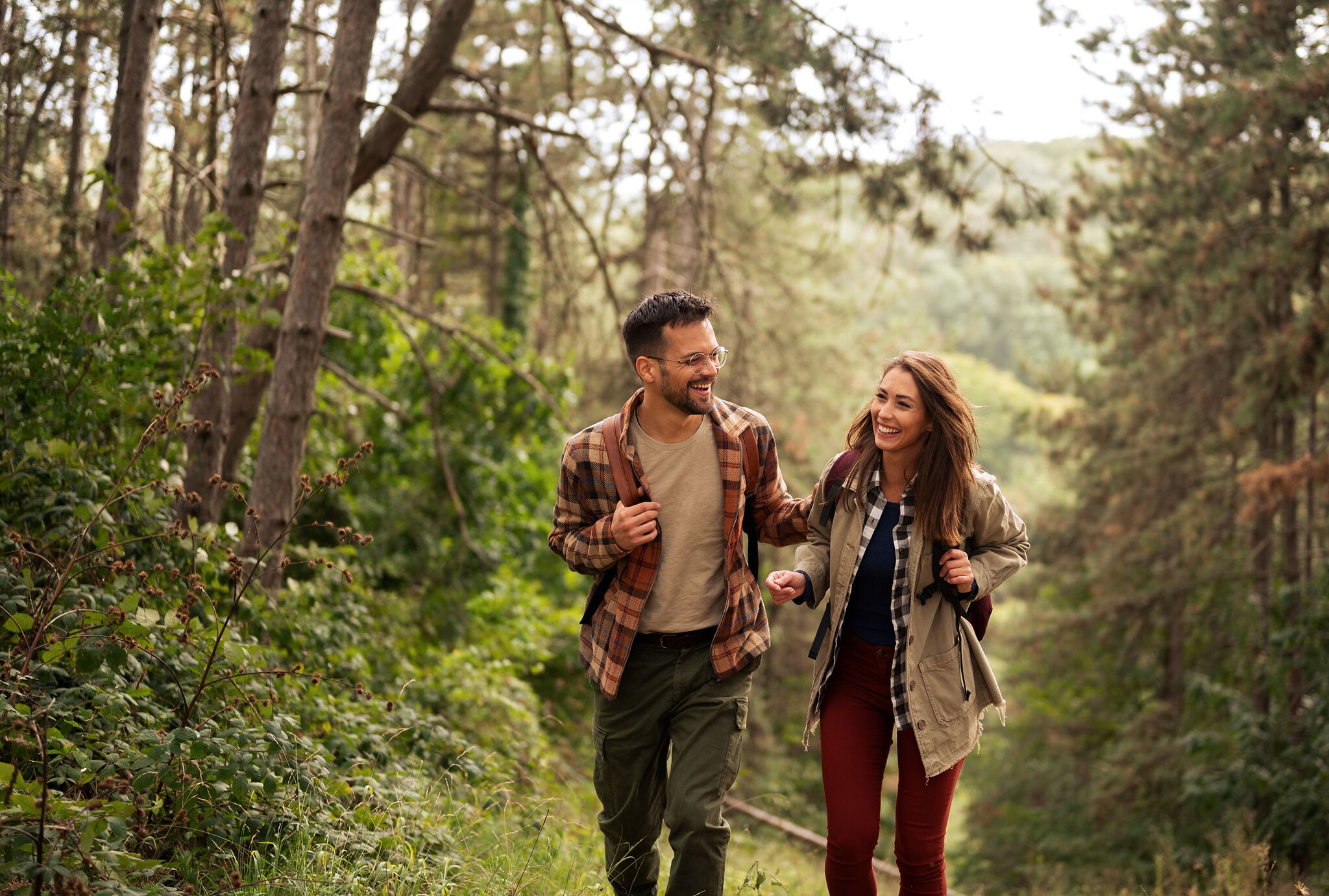 Eine Frau und ein Mann wandern im Wald.