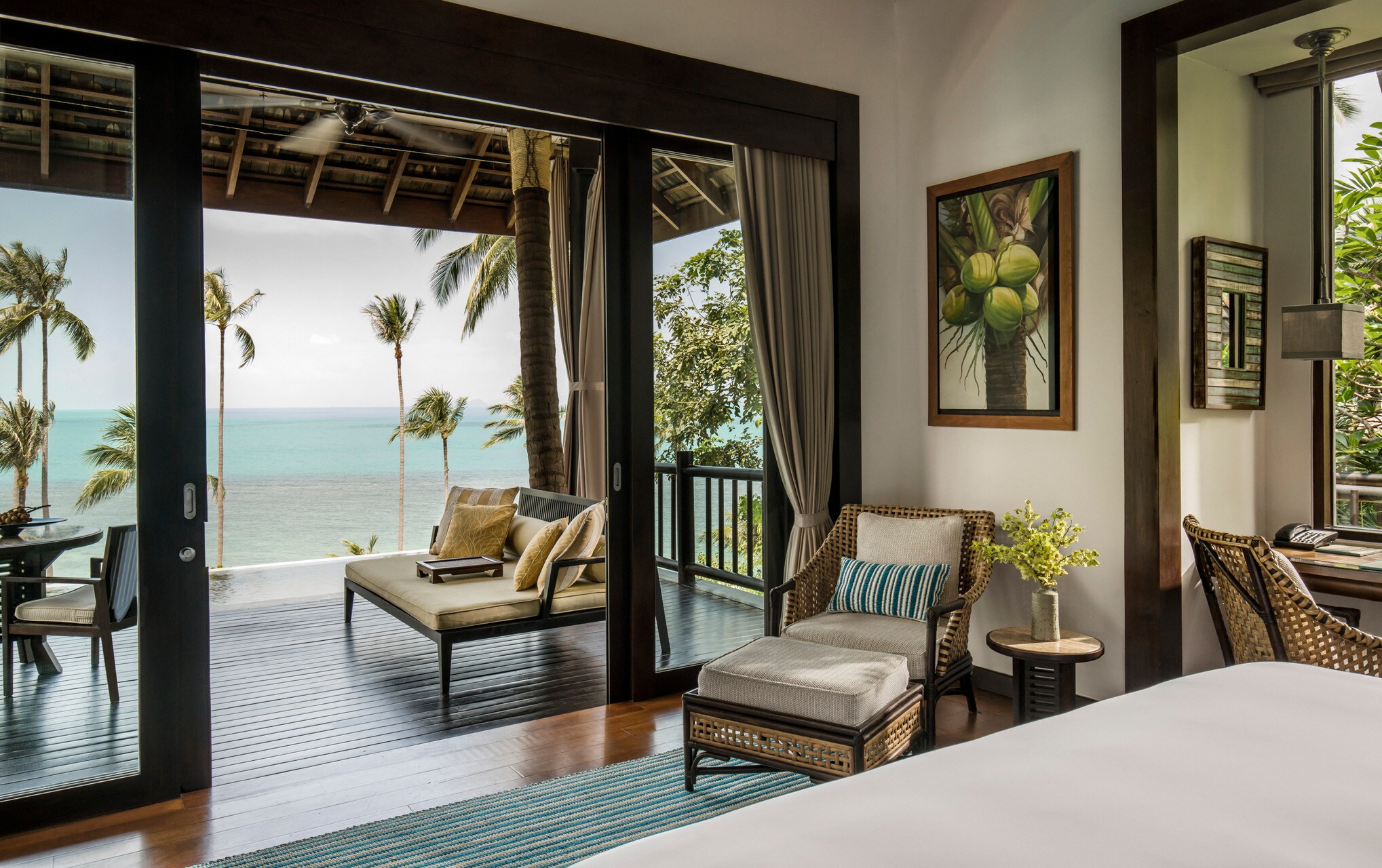 Villa Bedroom im Four Seasons Resort Koh Samui mit weiß bezogenem Bett und Blick auf Balkon, Meer und Palmen .