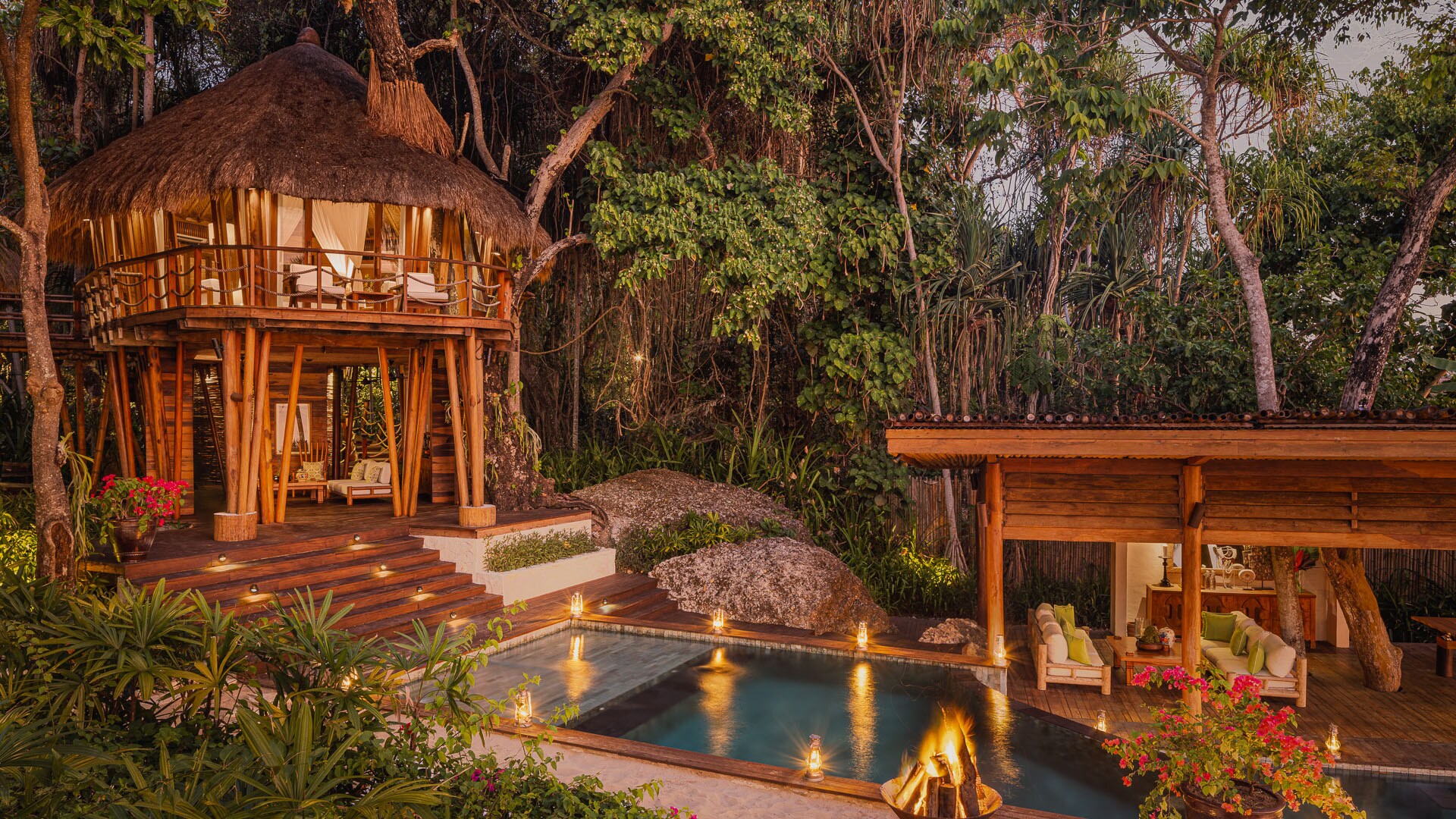An einem privaten Swimmingpool steht eine Holzhütte mit Schlafzimmer und Lounge.