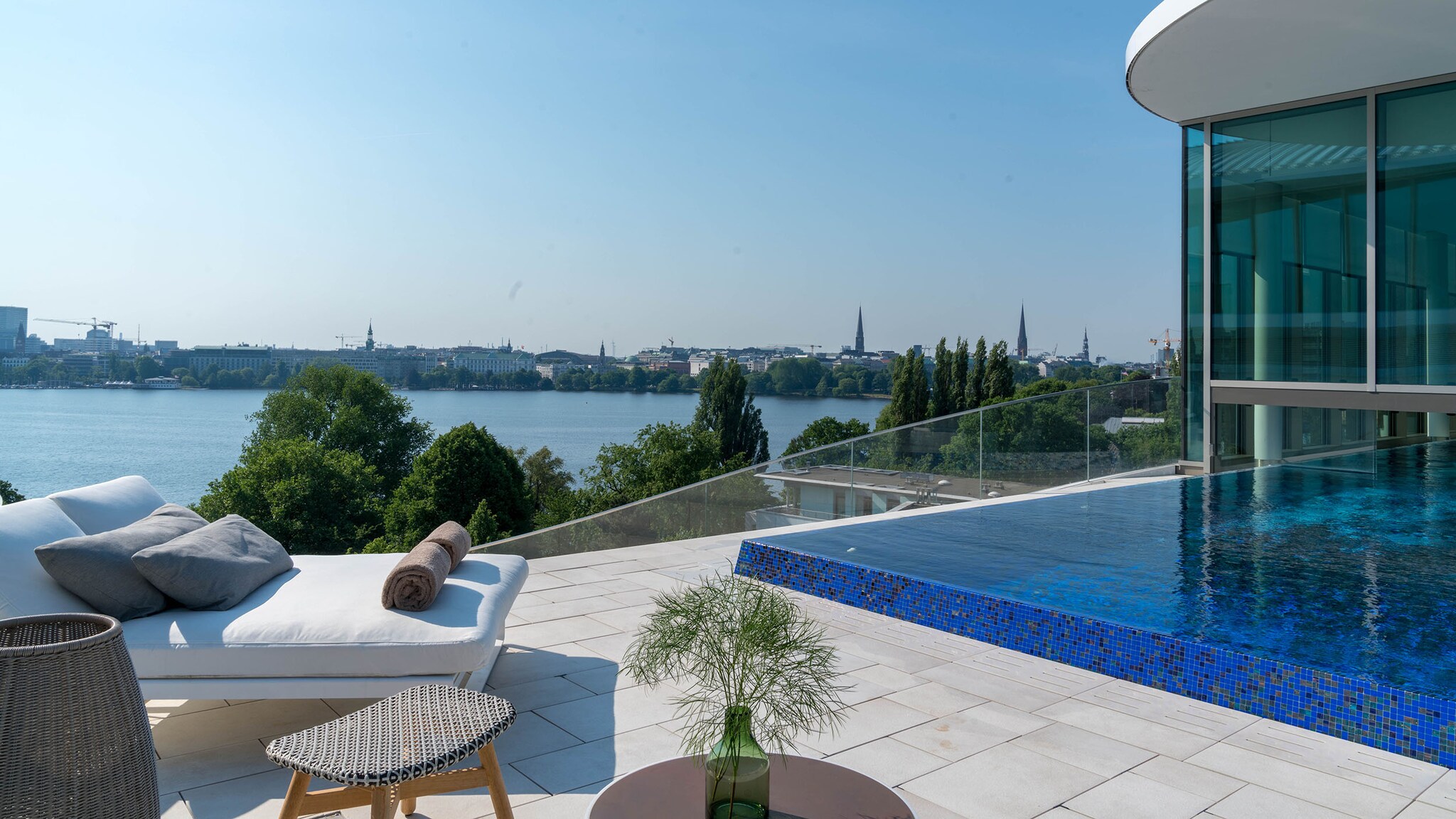 Dachterrasse mit Pool und Sonnenliegen an einem See in Hamburg.
