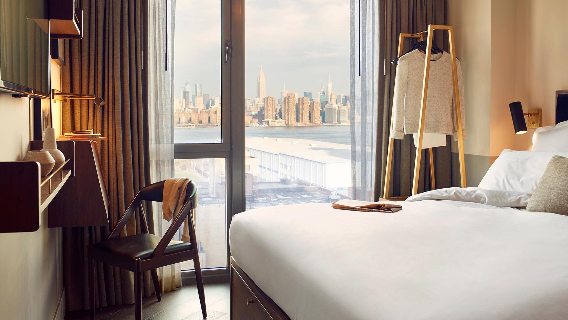Stilvolles Hotelzimmer mit Blick auf Skyline von Manhattan durch Panoramafenster.