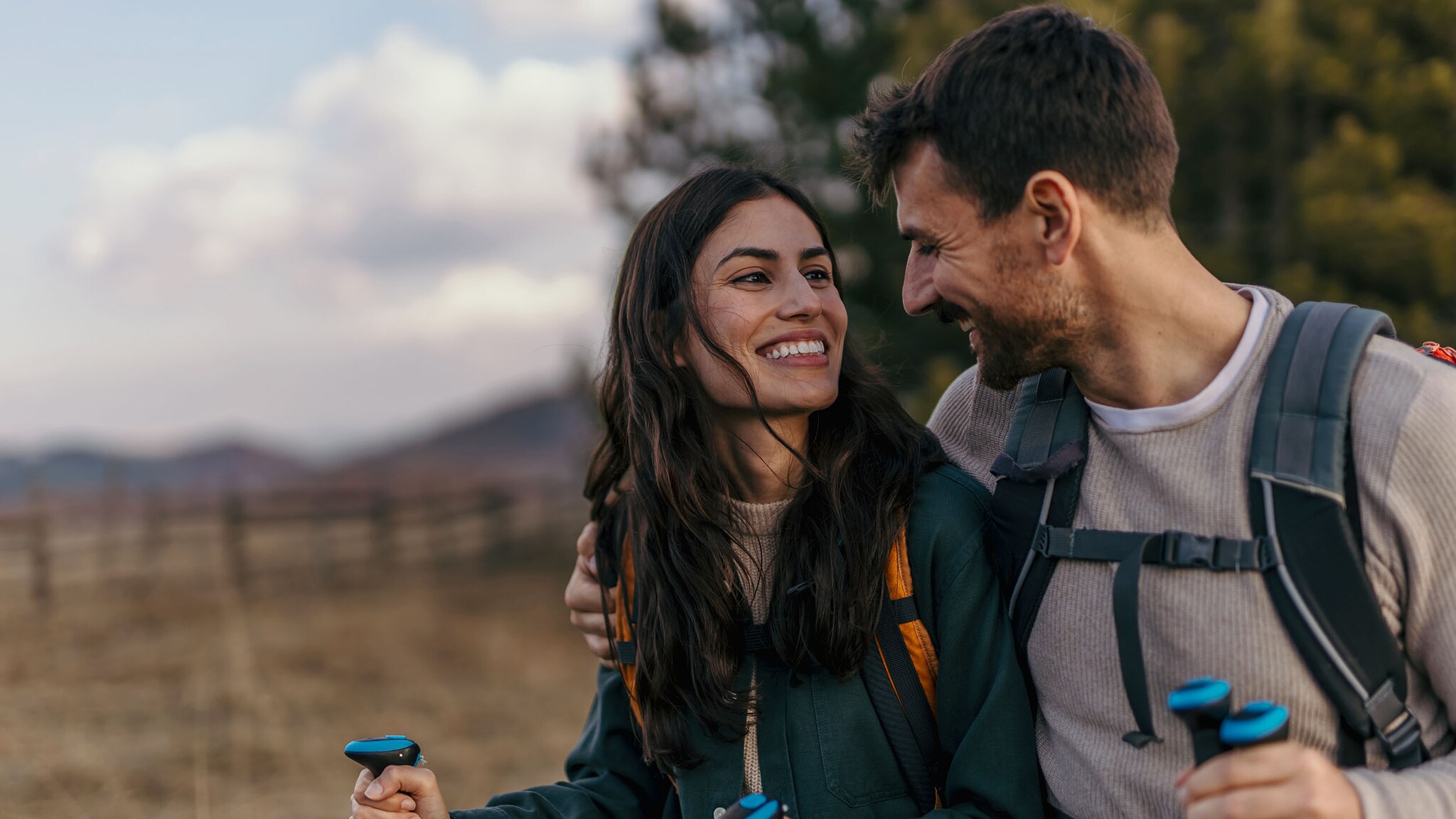 Eine Frau und ein Mann wandern und schauen sich dabei an.