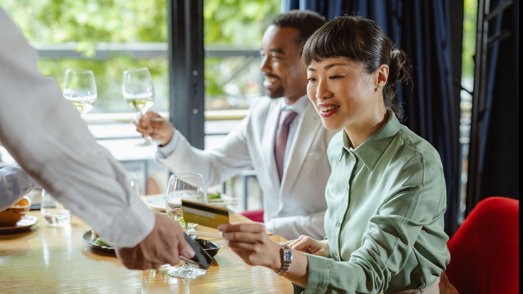Eine Frau bezahlt mit einer Kreditkarte in einem Restaurant.