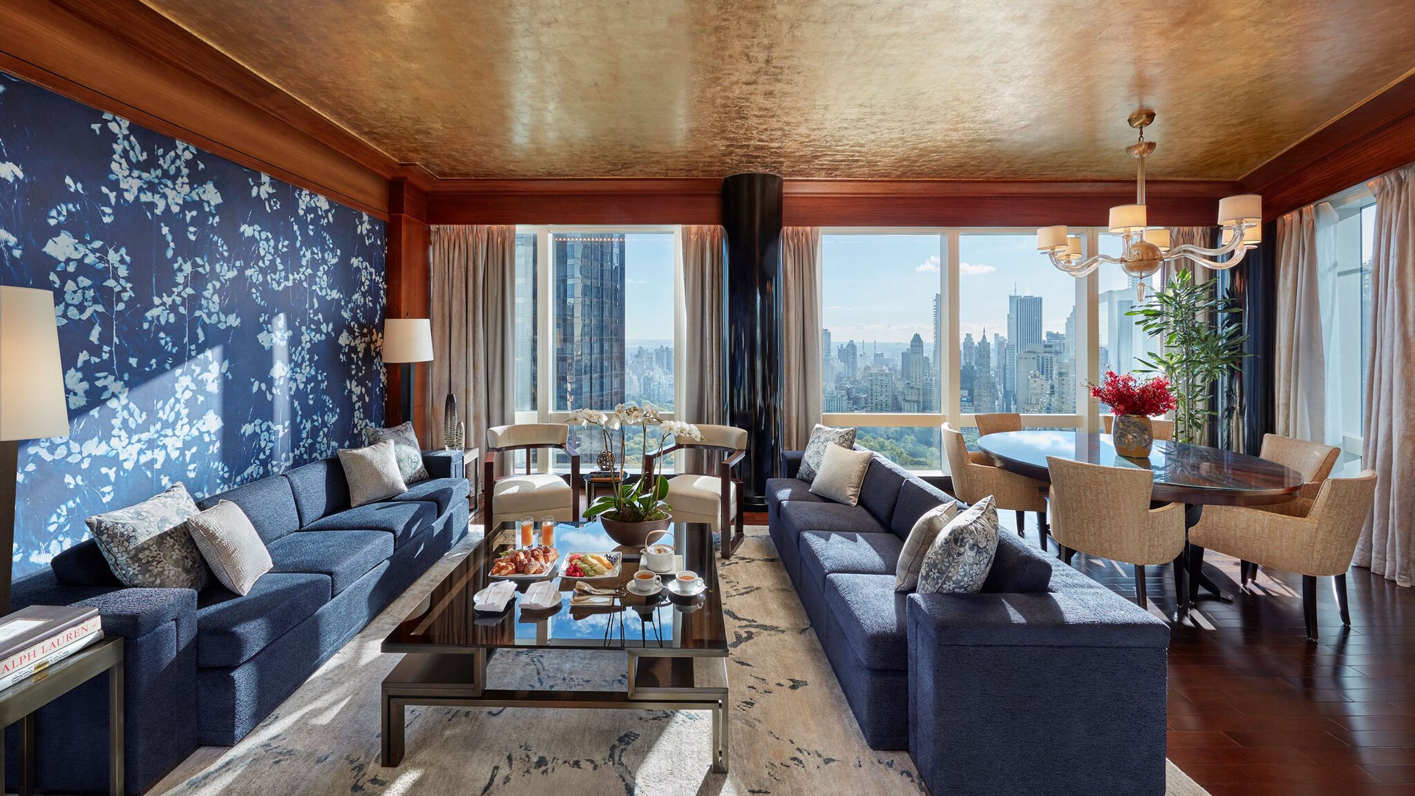 Eine Hotelsuite ist im orientalischen Stil eingerichtet, von den Fenstern aus kann man die Skyline einer Stadt sehen.