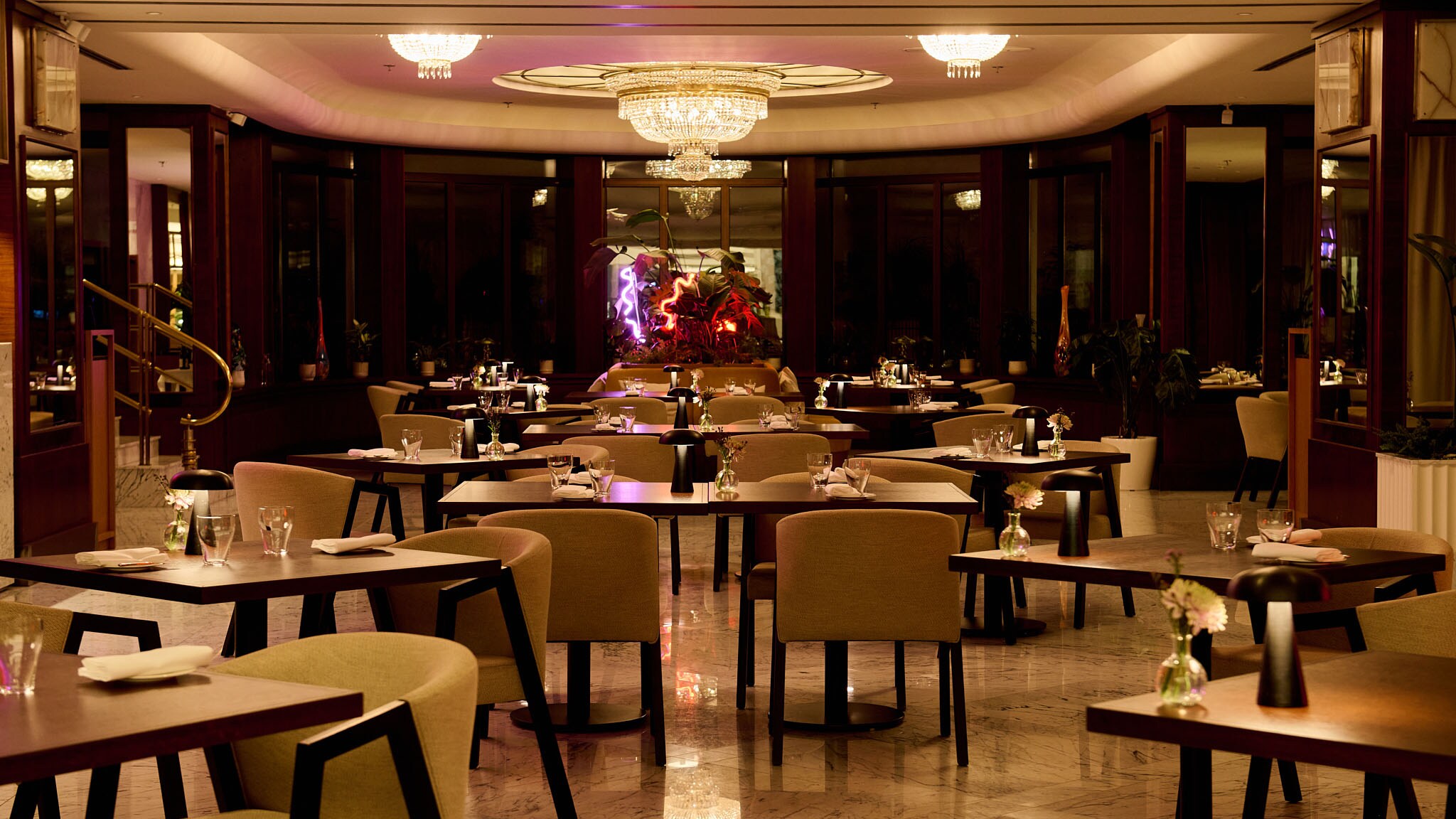 Menschenlerer Speisesaal m Brasserie-Stil mit Beleuchtung im warmer Lichtfarbe.